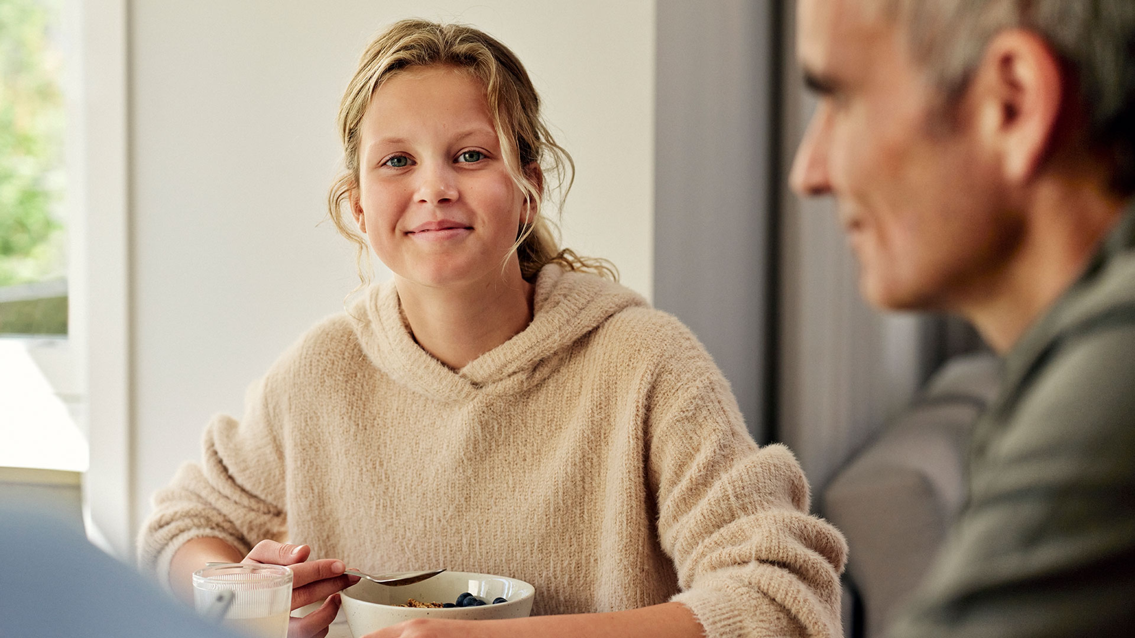 tonårstjej och hennes pappa vid köksbordet