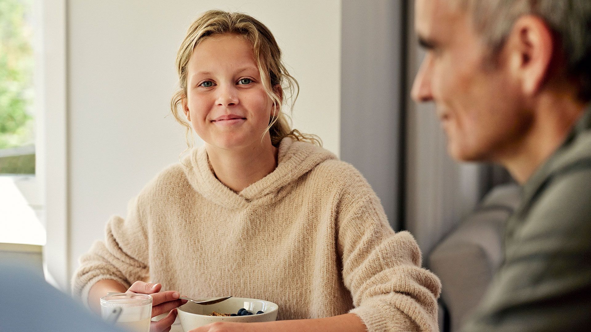tonårstjej och hennes pappa vid köksbordet