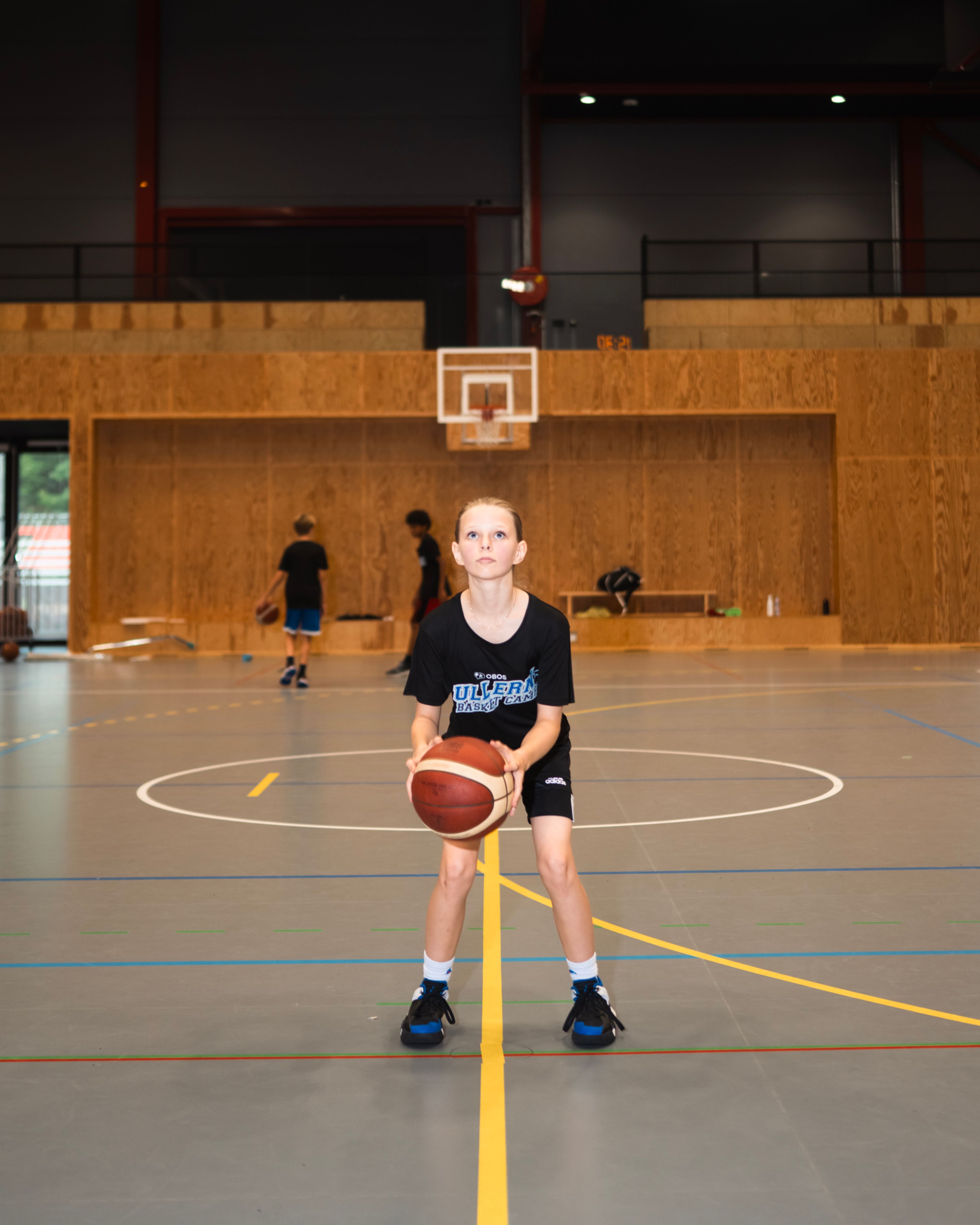 Ei jente står ved straffemerket på basketbanen og gjør seg klar til å skyte.