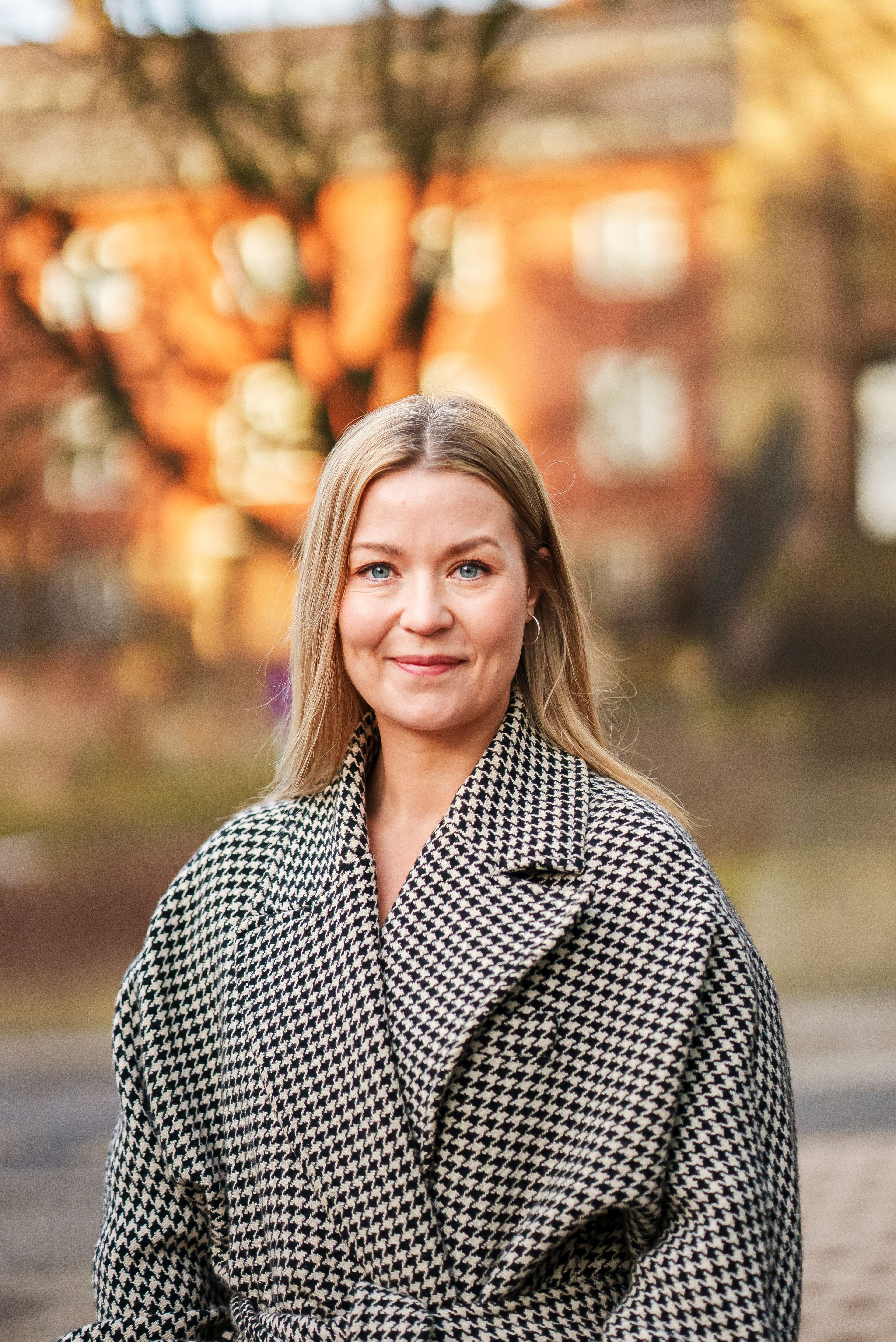 Bilde av Tonje Hovde Skjelbostad, advokat og daglig leder i advokatfirmaet Legalis. Hun har på seg en kåpe. Det er høst ute og hun smiler.