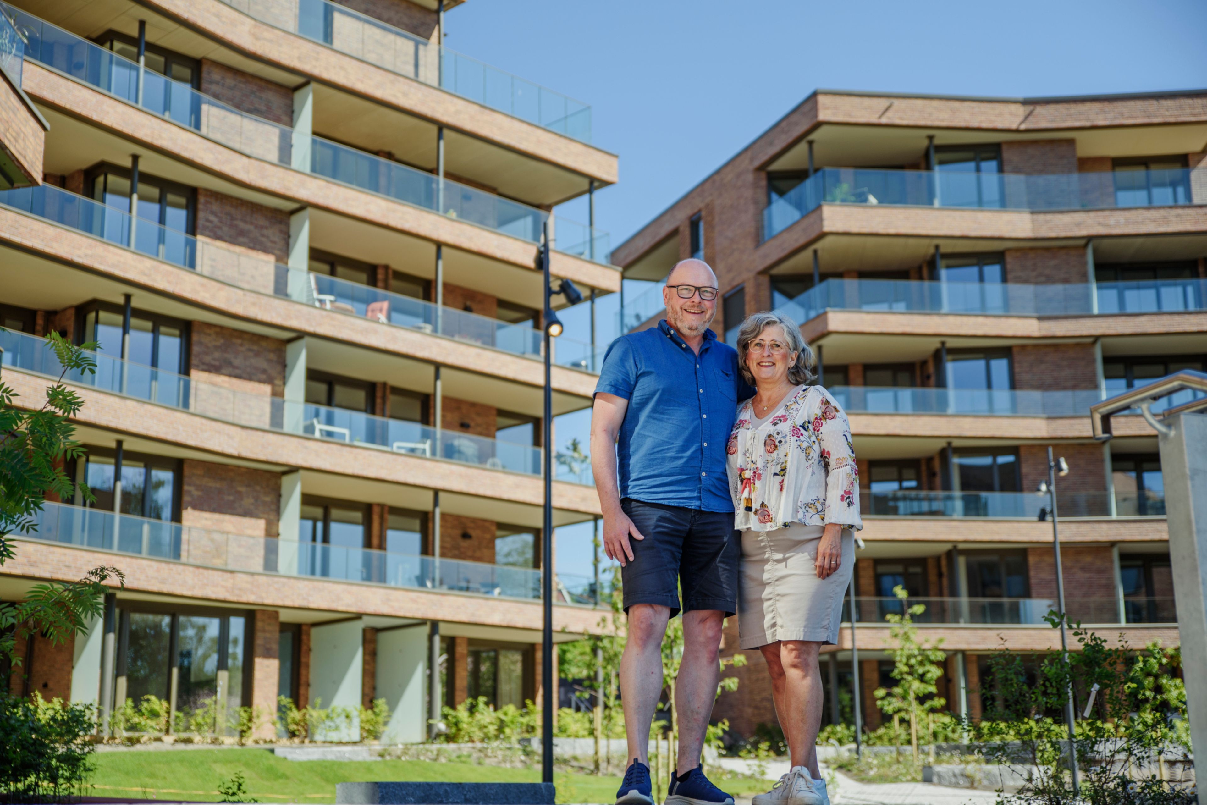 Tom og Lise står foran fasaden til Hoffsveien Hage, som bader i solskinn