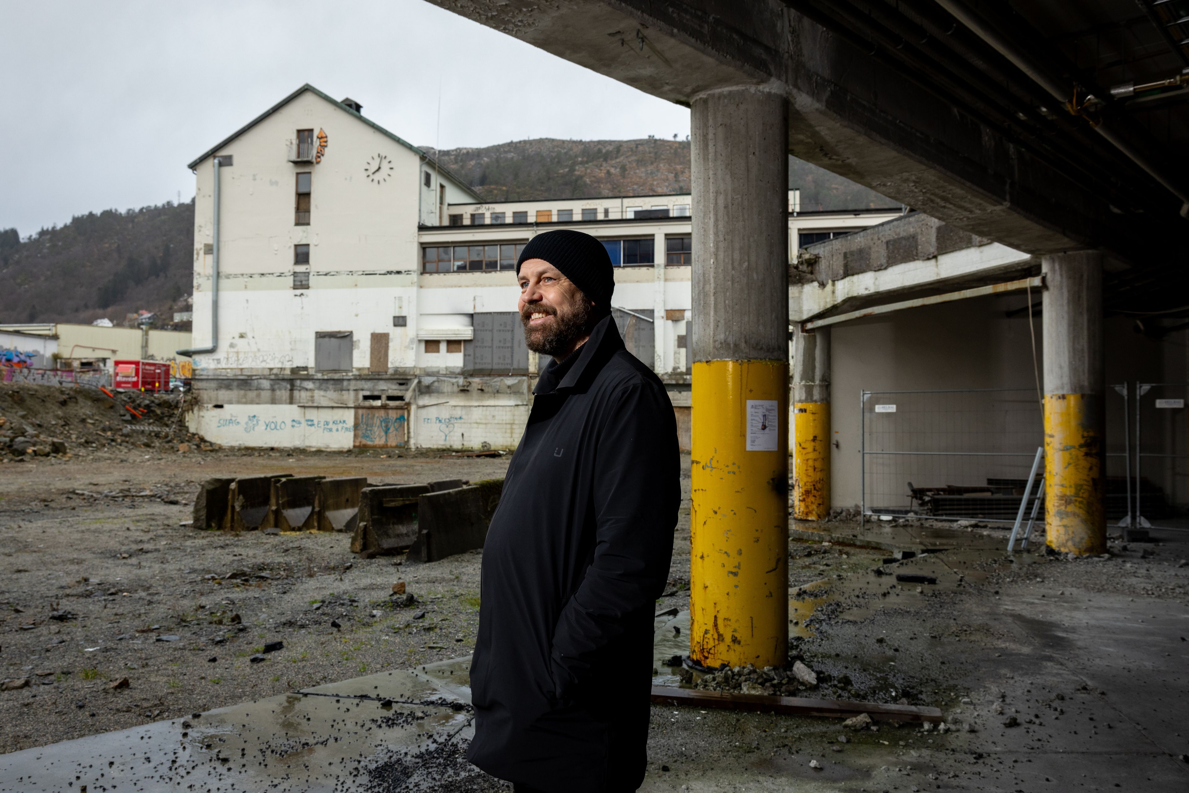 Arkitekt Fredrik Barth smiler foran tapperibygningen på byggetomten.