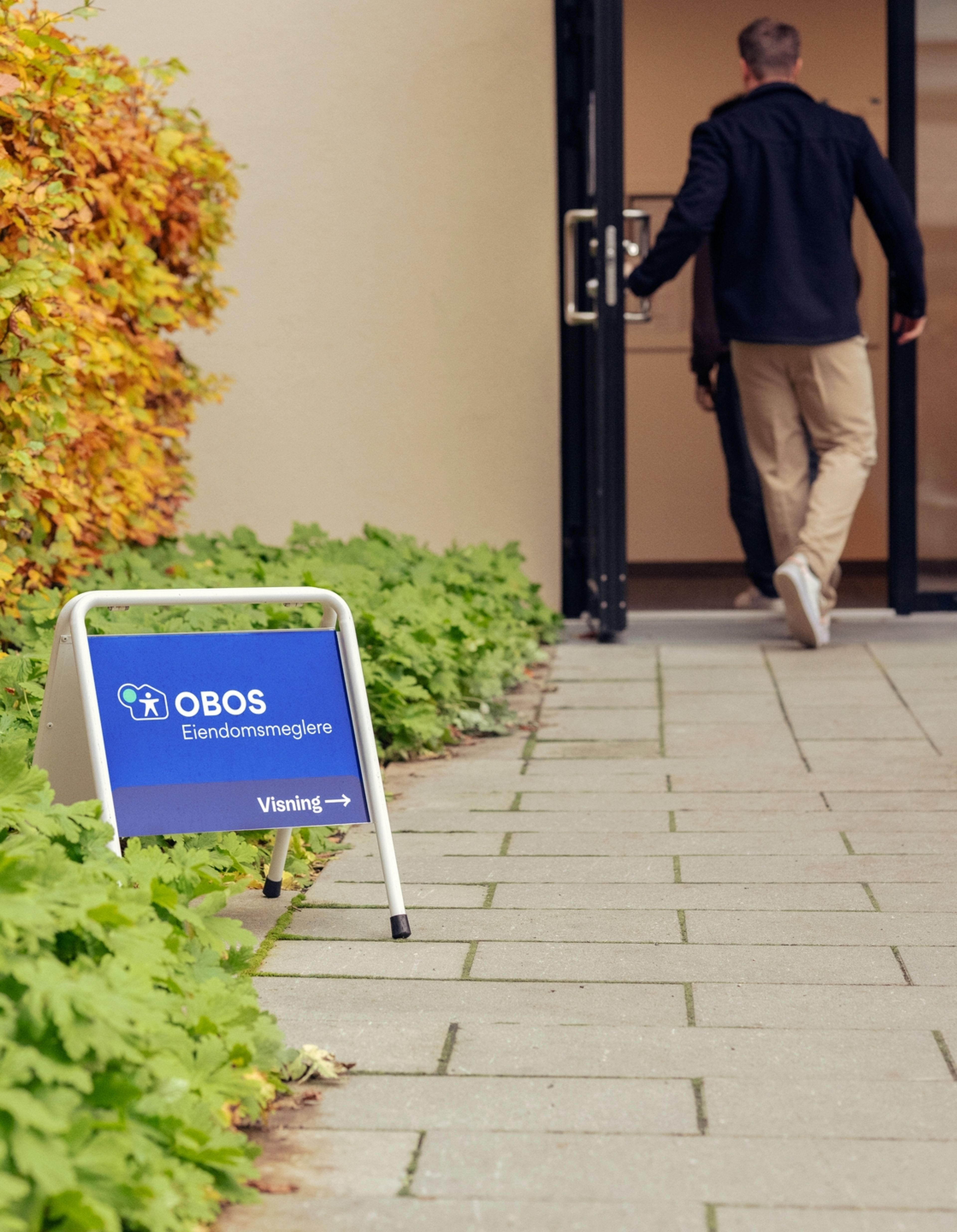 OBOS visningskilt i bakgården og mennesker på vei til visning.
