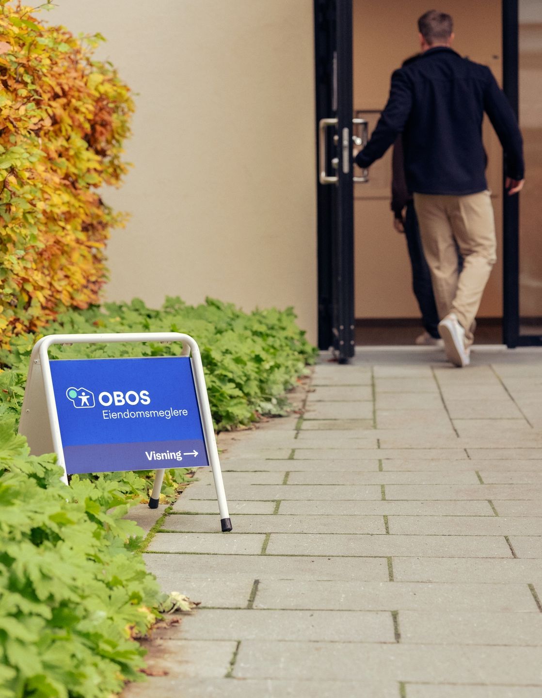 OBOS visningskilt i bakgården og mennesker på vei til visning.