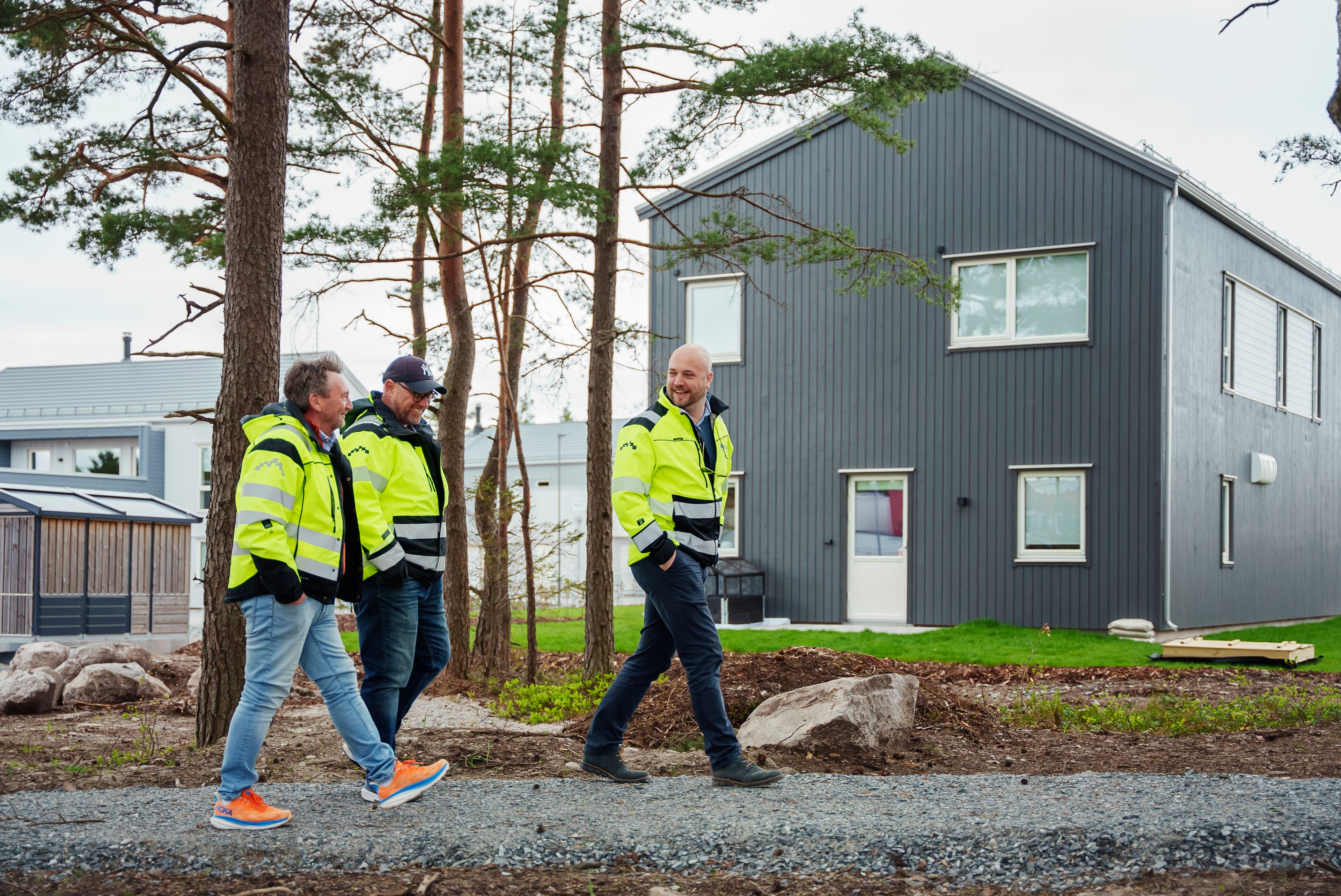 Foto av prosjektleder, driftsleder og byggeleder foran Svanemerket OBOS Block Watne-enebolig i Begbyåsen
