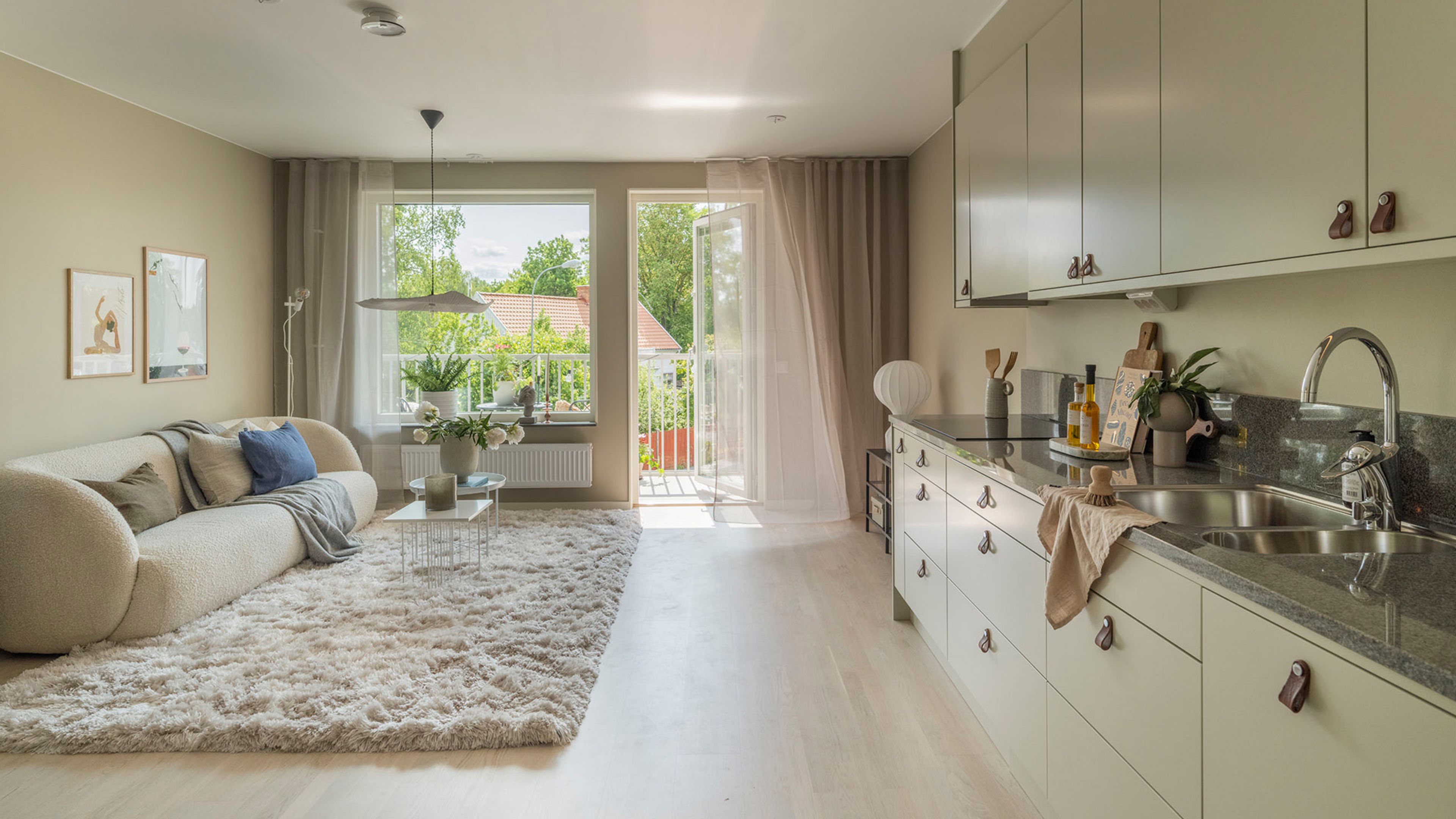 Ljus bostad som visar kök och vardagsrum i öppen planlösning