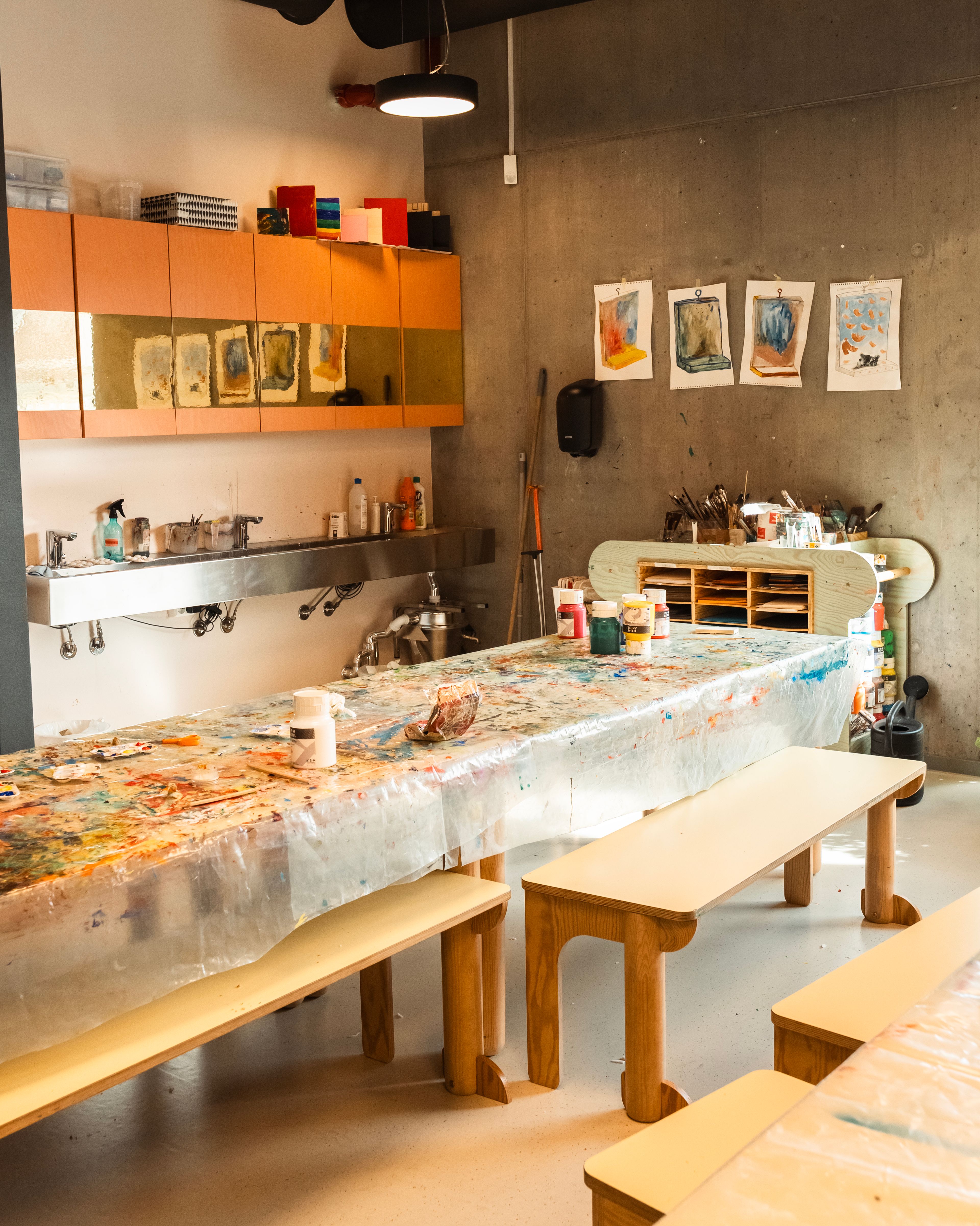 Langbord med maling og duk hvor både voksne og barn kan komme og lage kunst.