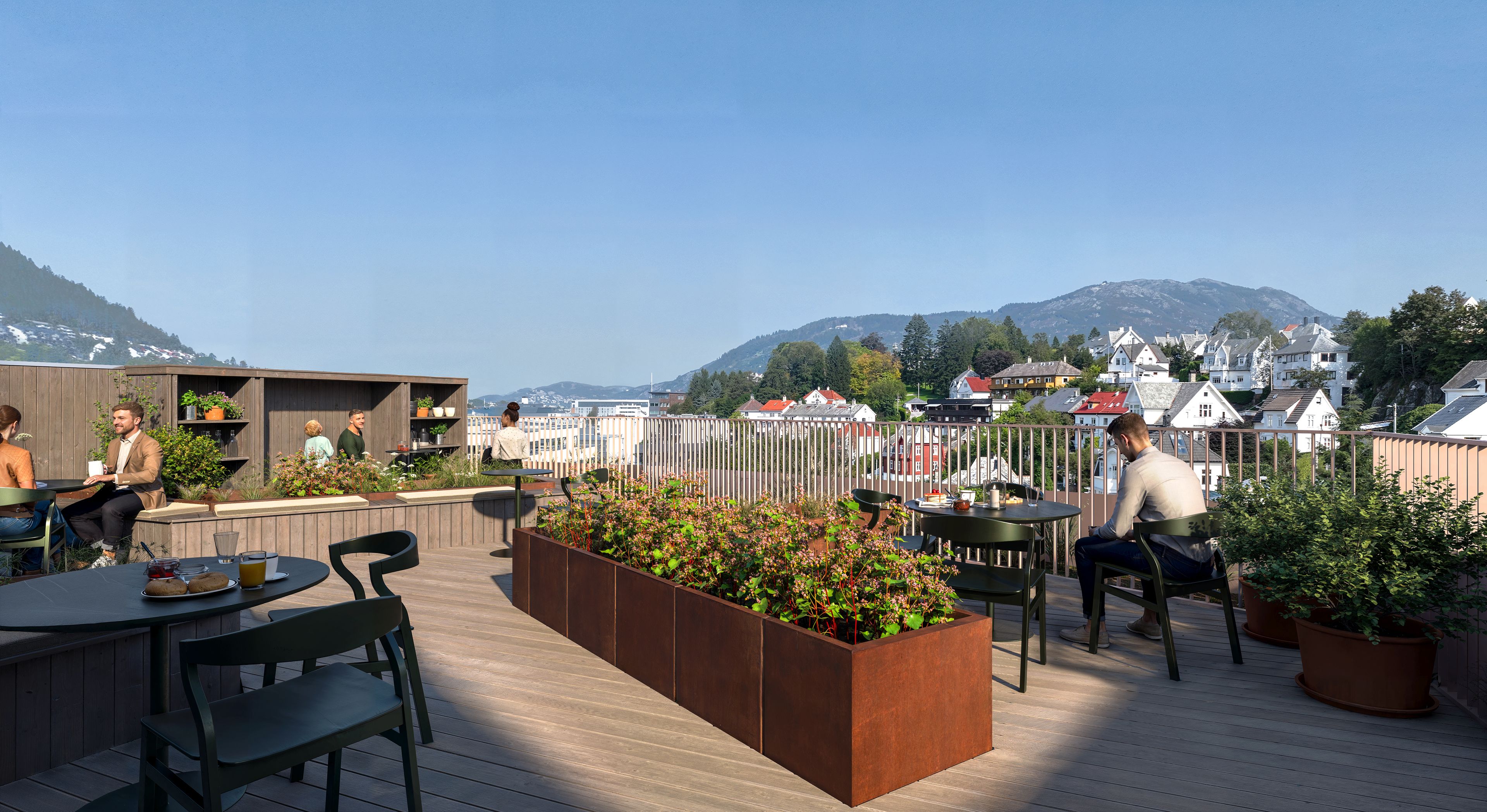 Felles takterrasse med sittegrupper, plantekasser og utsikt mot nærområdet.