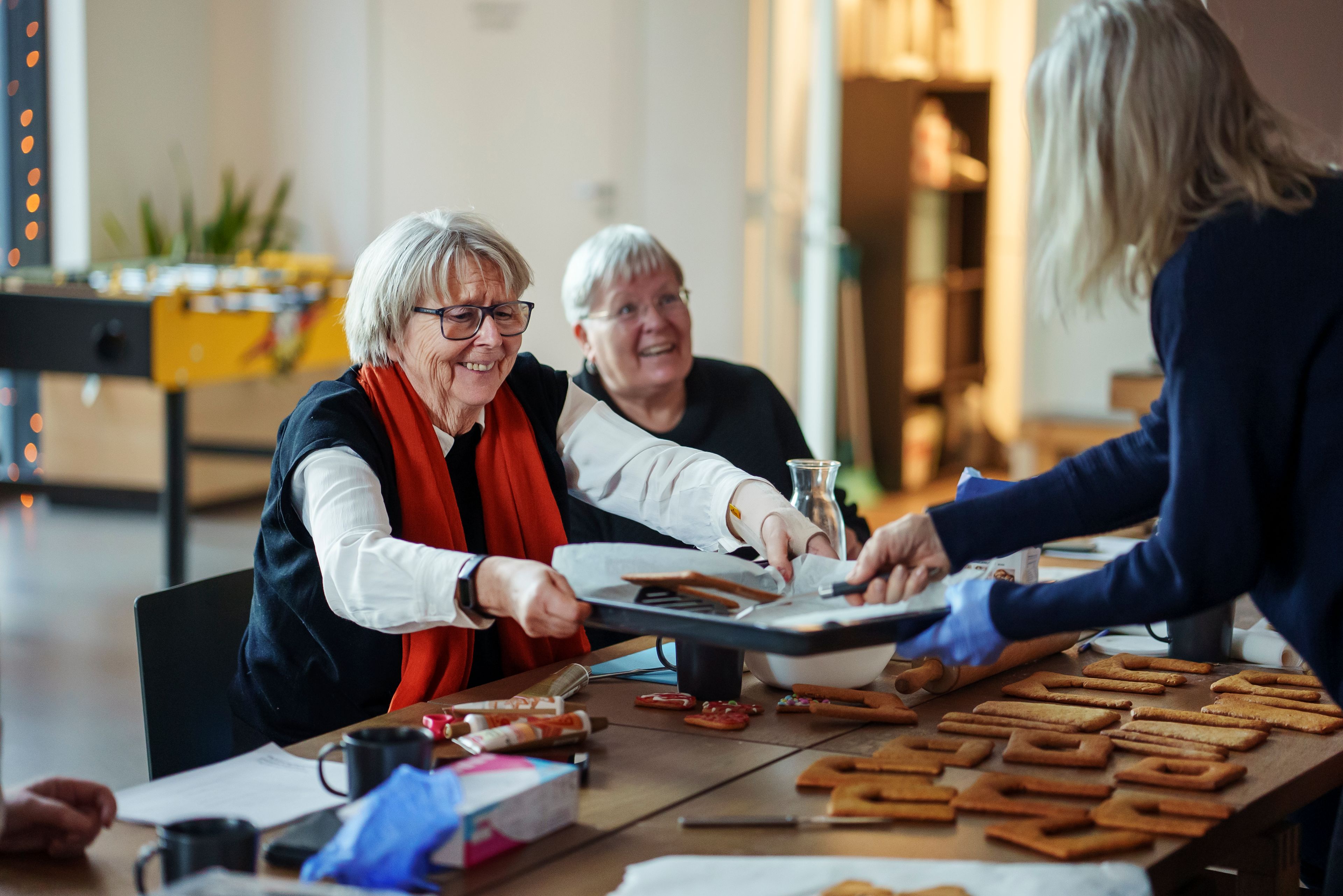 Marit Holen tar imot et brett med pepperkaker på seniortreff
