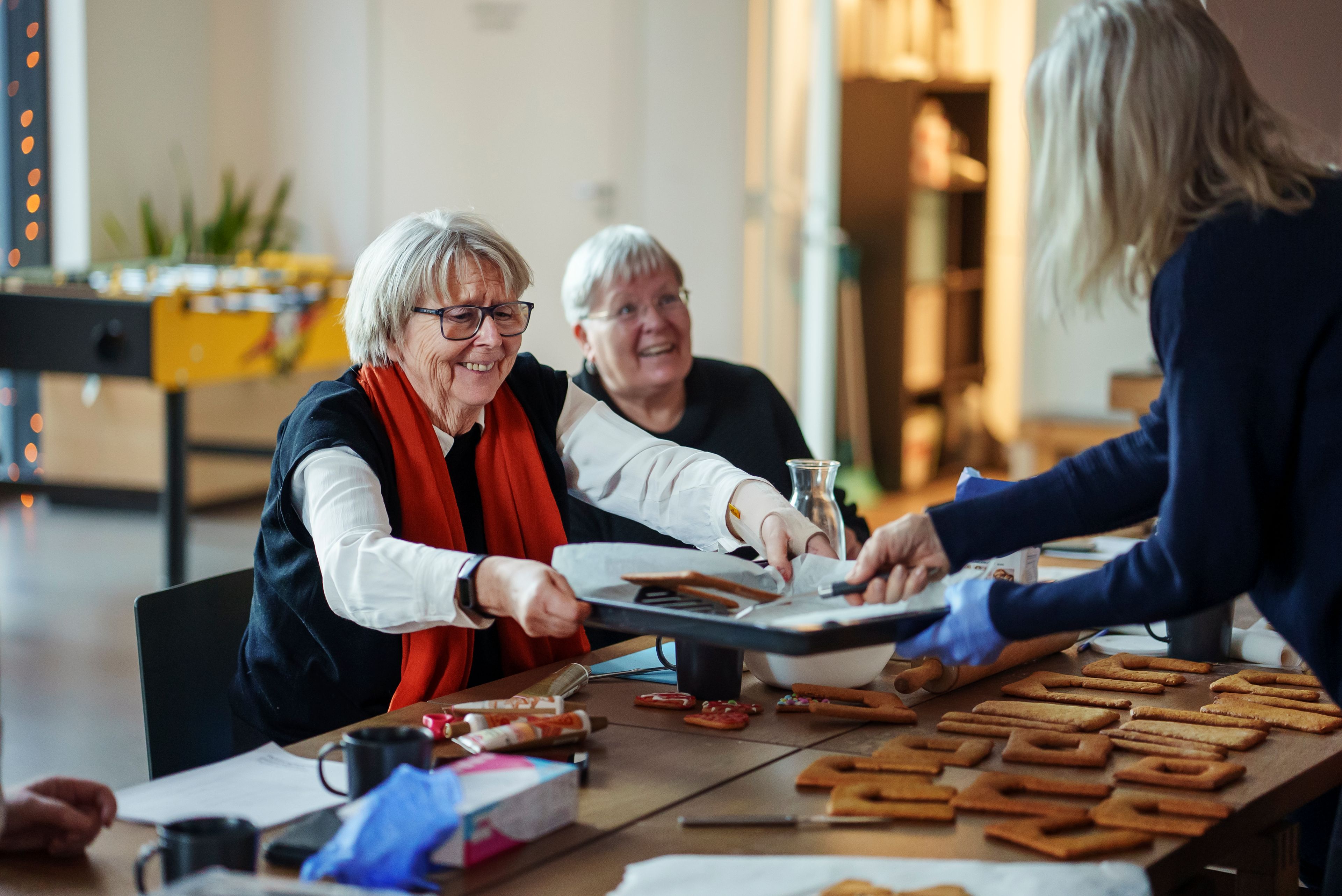 Marit Holen tar imot et brett med pepperkaker på seniortreff