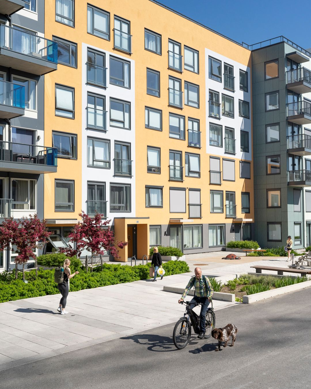 Foto av fasaden til boligprosjektet Vollebekk Torgkvartal med liv mellom husene.