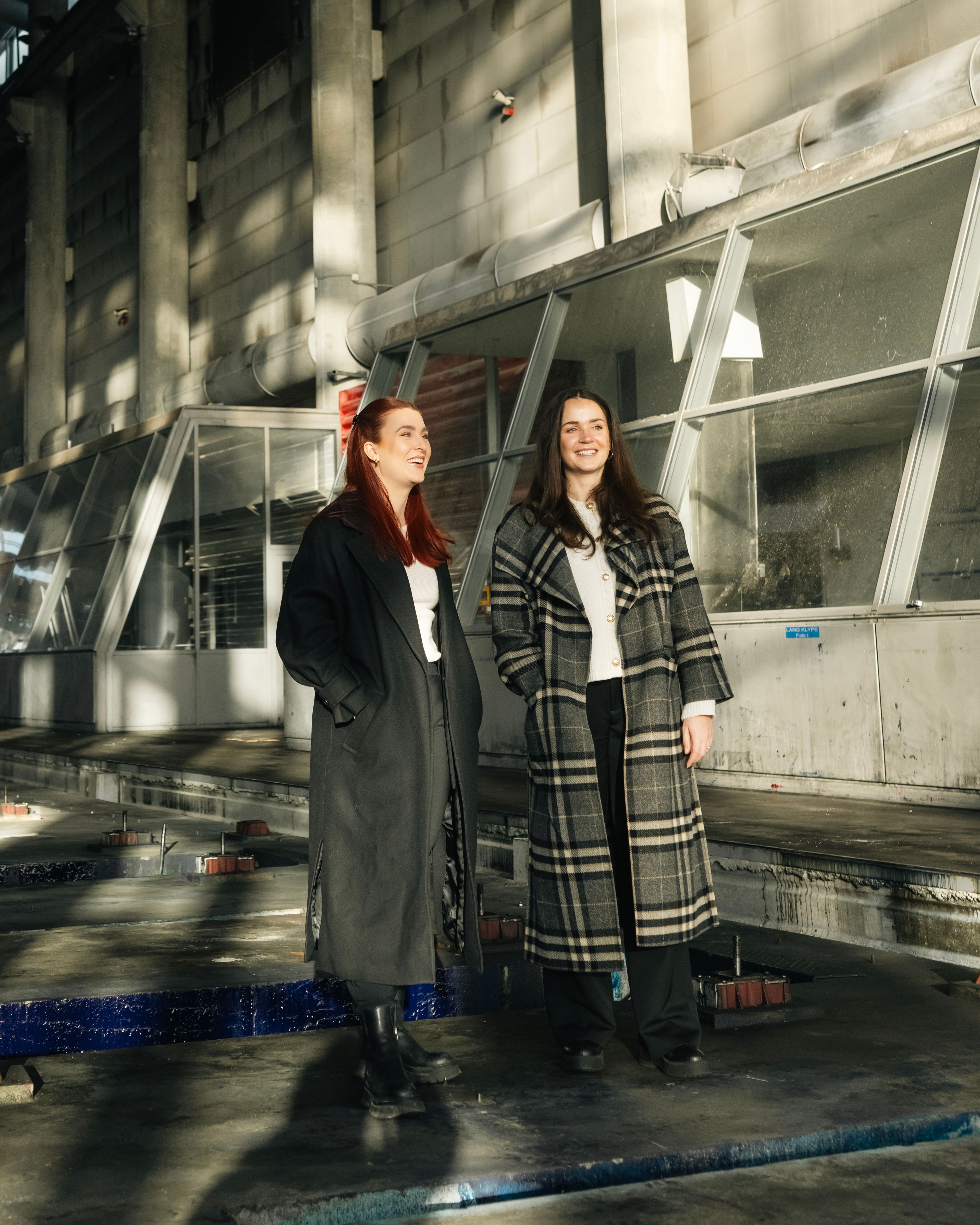 Foto av prosjektleder Karoline Forsnes Krogstad og prosjektselger Mariell Veinan i de gamle trykkerihallene i Nydalen.