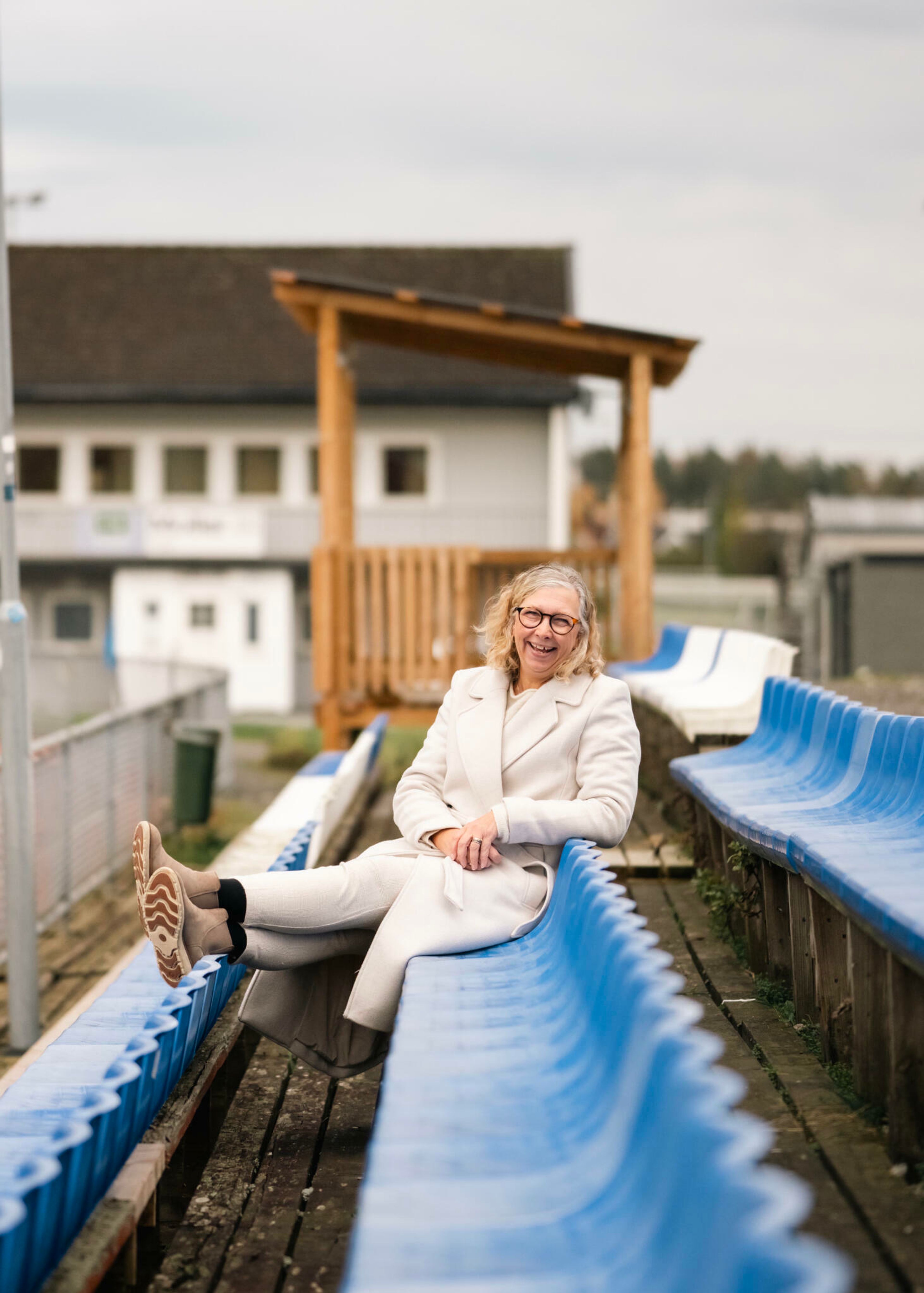 Foto av Camilla Melsgard, prosjektselger i OBOS, sittende i tribunen på Ski stadion