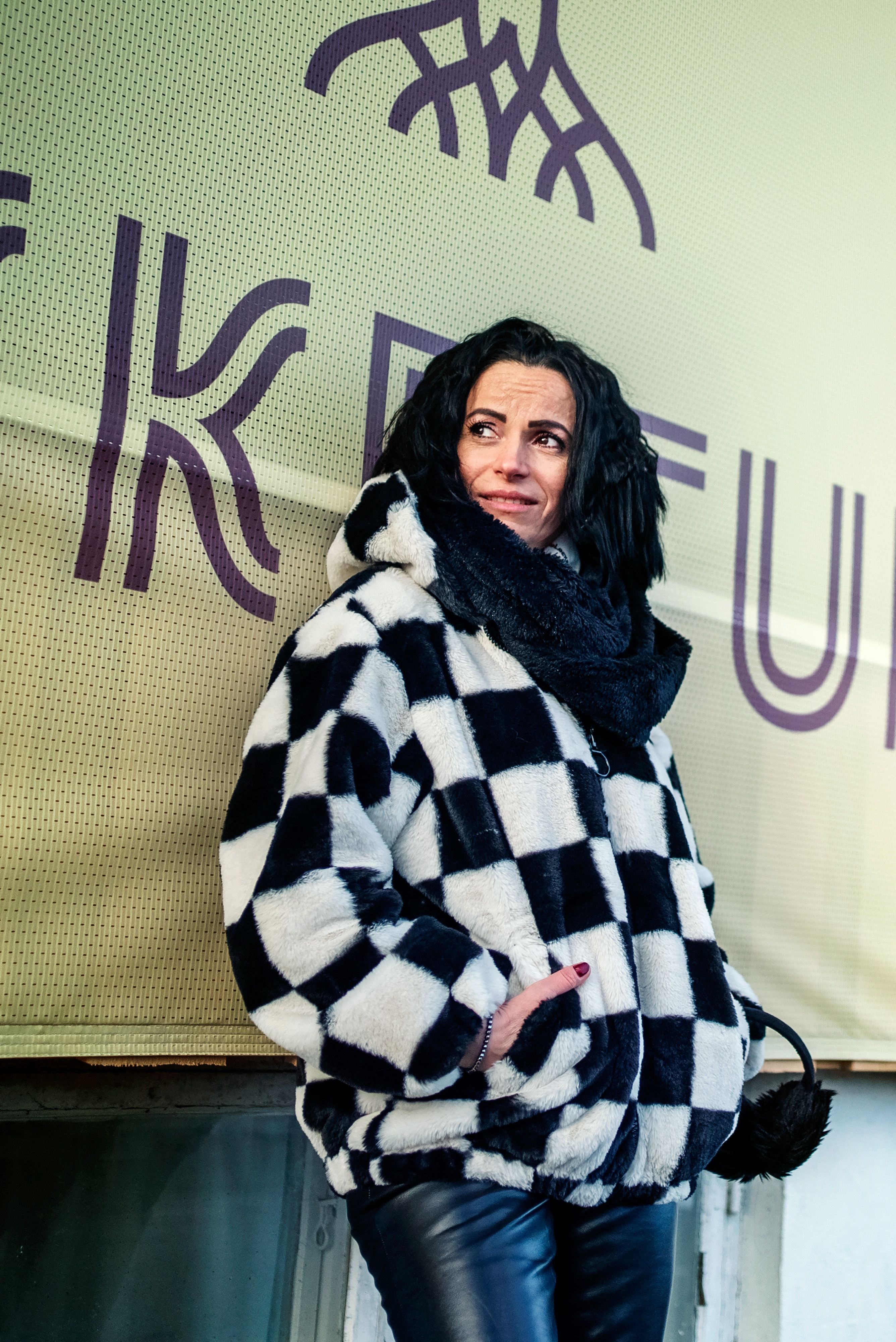 Mihaela lener seg mot en vegg med en plakat for Brekketunet.