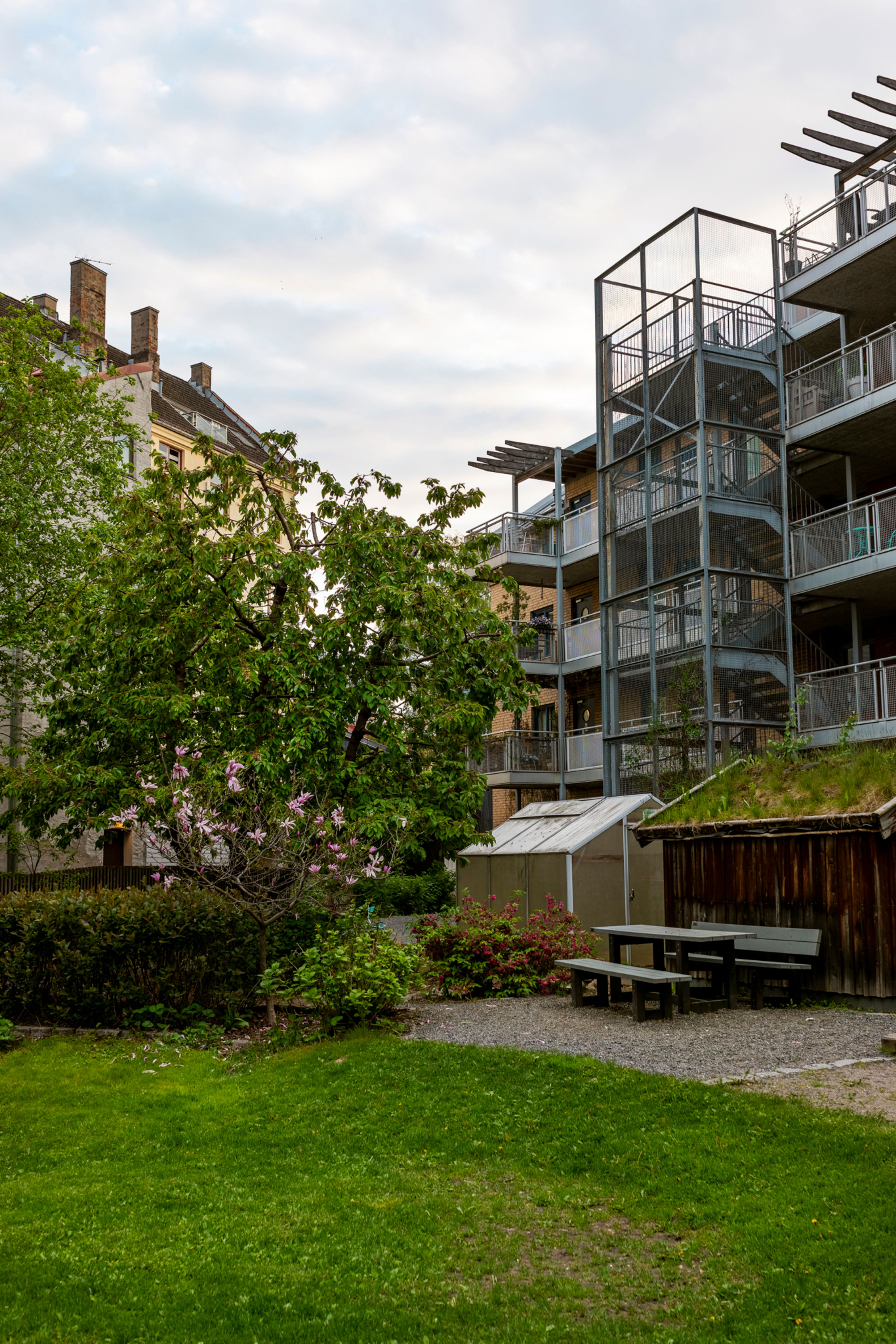 Bilde av deler av hagen i Byhagen borettslag og noe fasade.