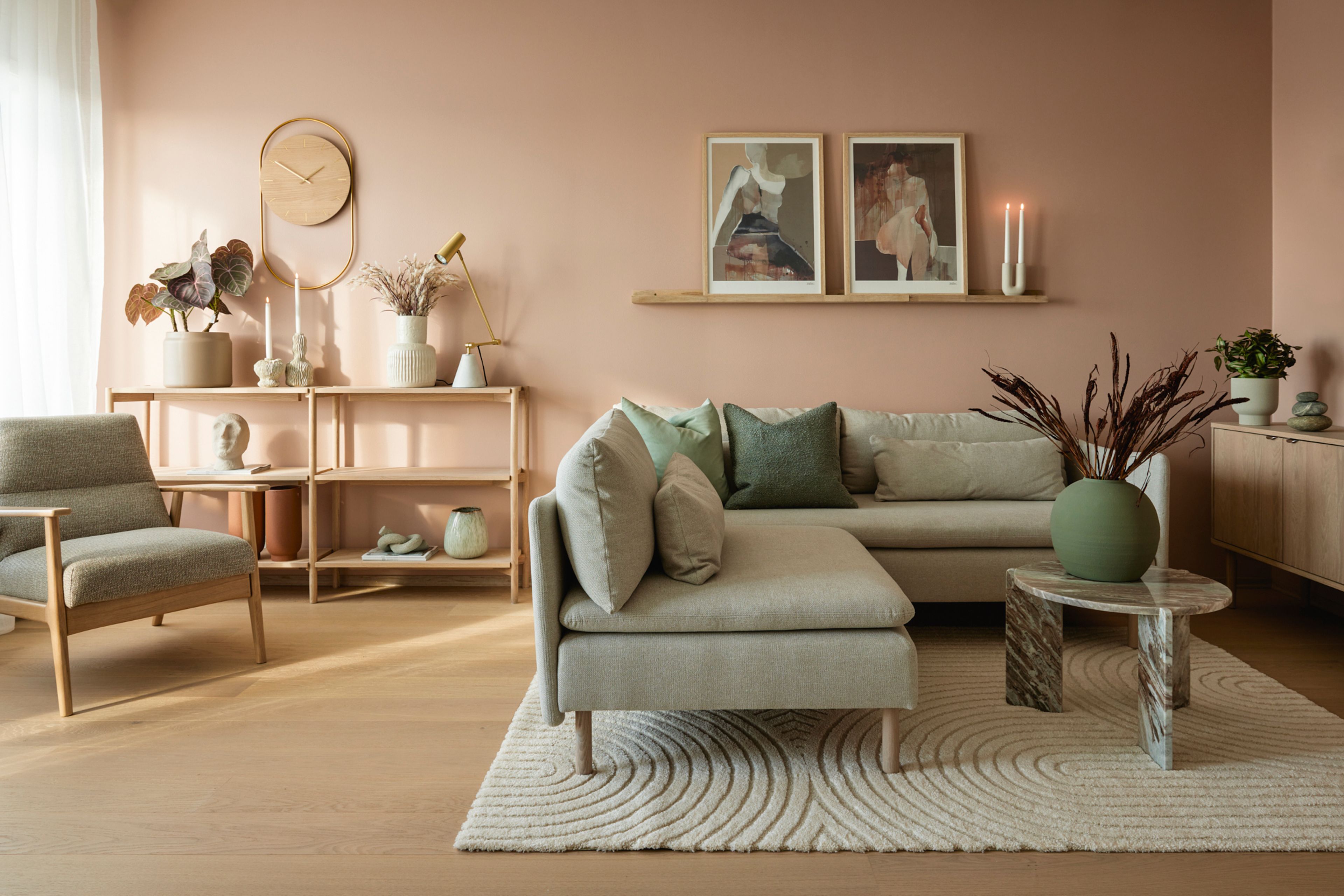 Visningsleilighet på Vollebekk, stue med sofa rosa vegger og interiørdetaljer.