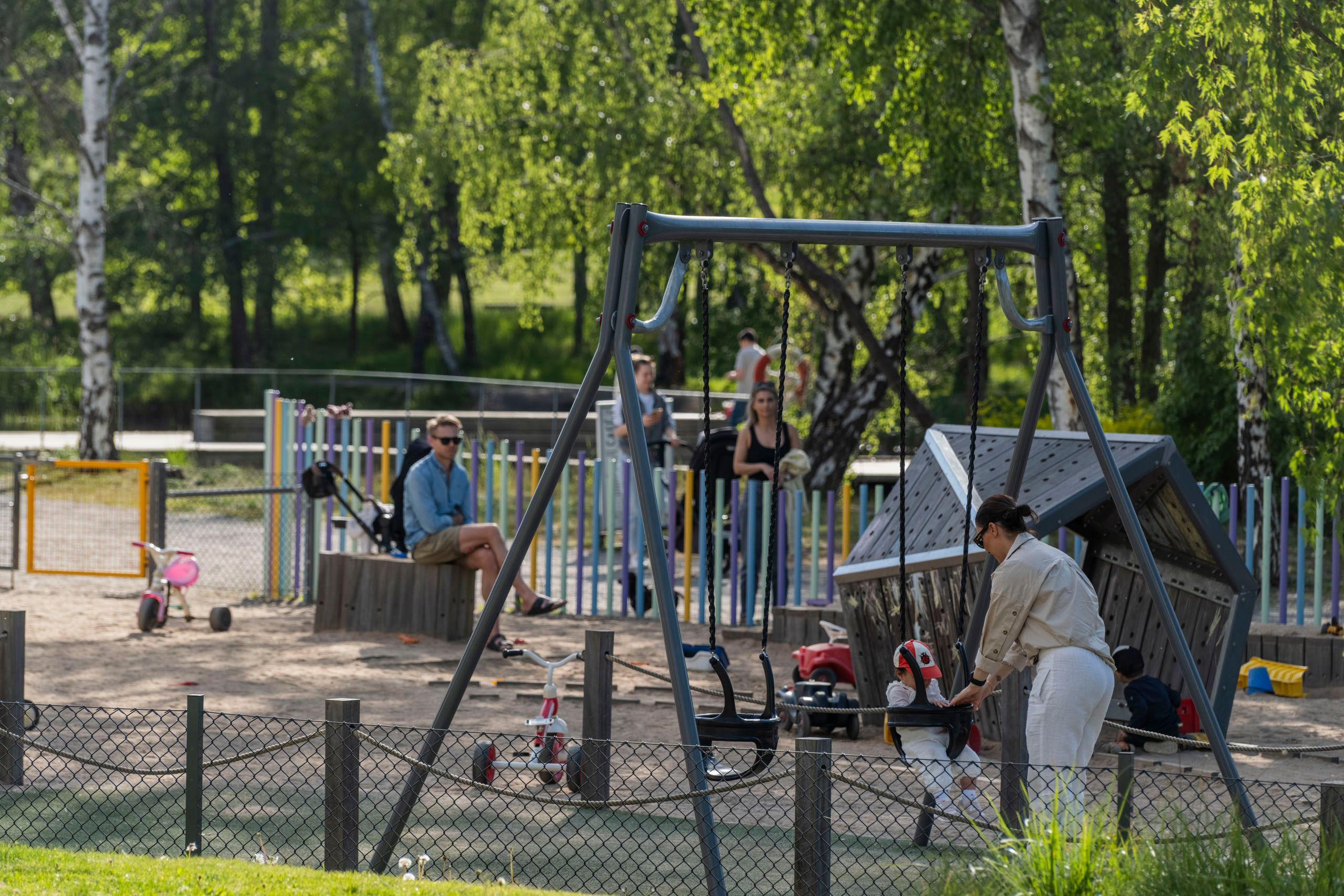 Barn och föräldrar i en lekpark
