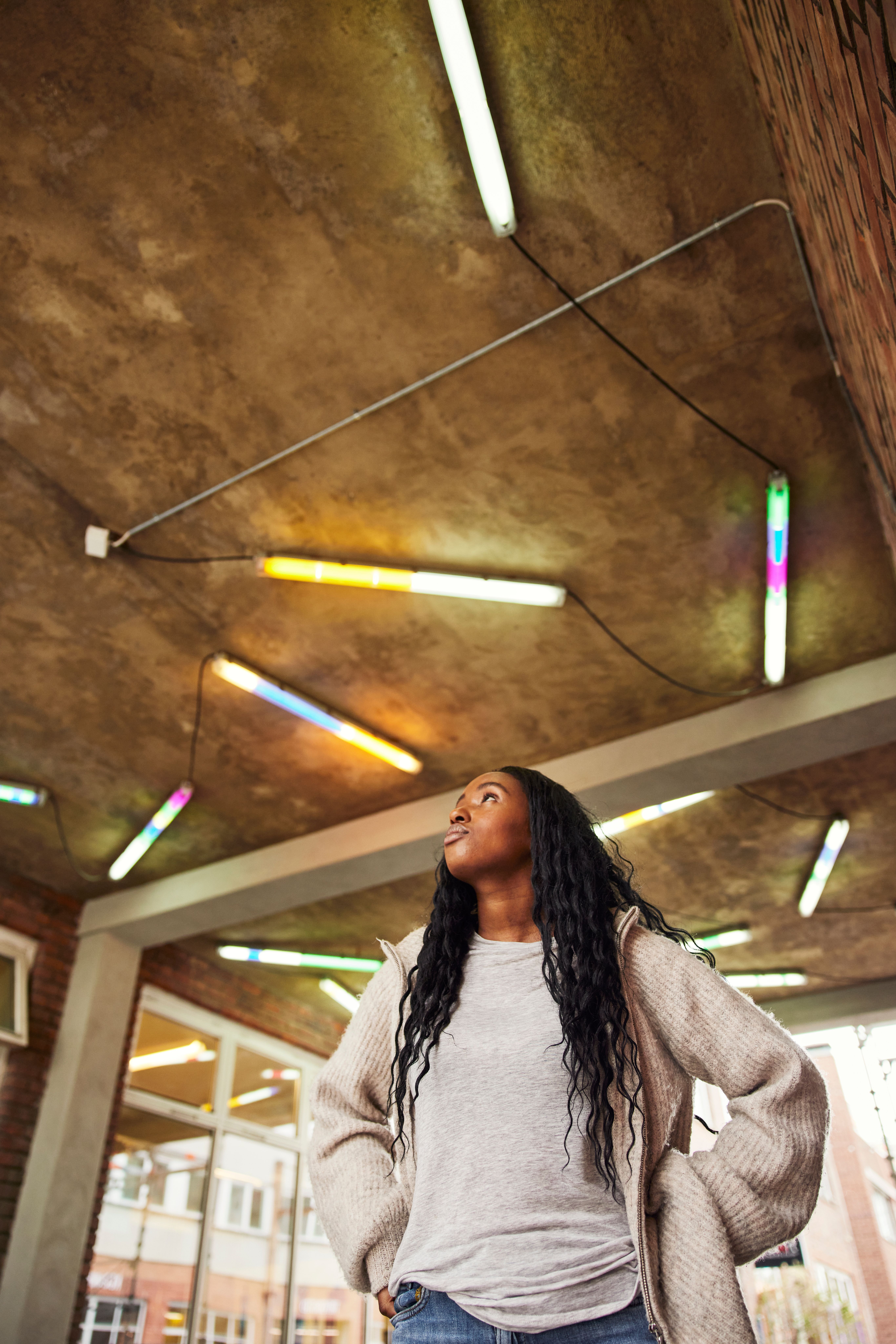Kvinne som ser opp på kunstinstallasjon i taket.