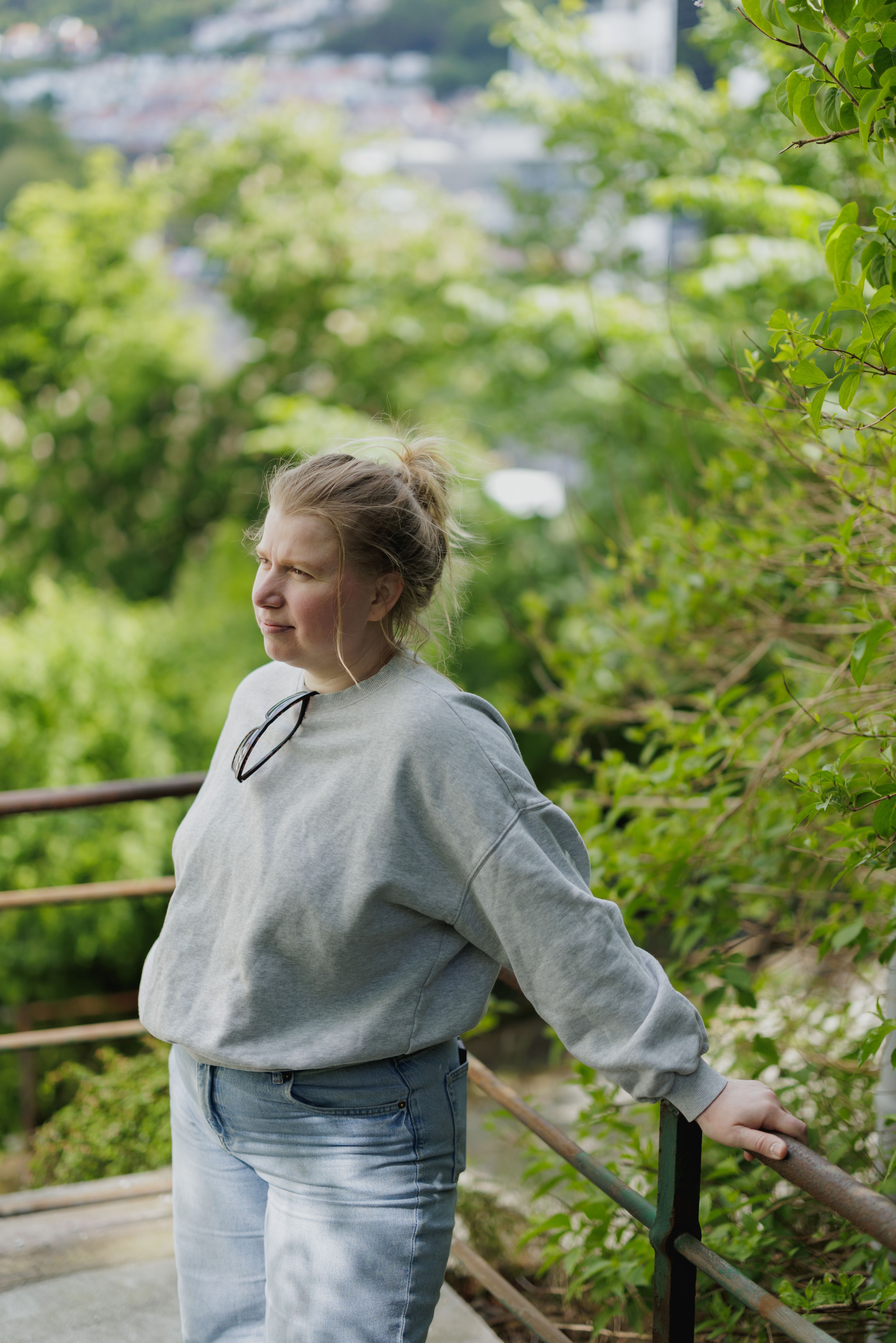 Viktoria lener seg mot et gjerde mot en grønn og frodig bakgrunn