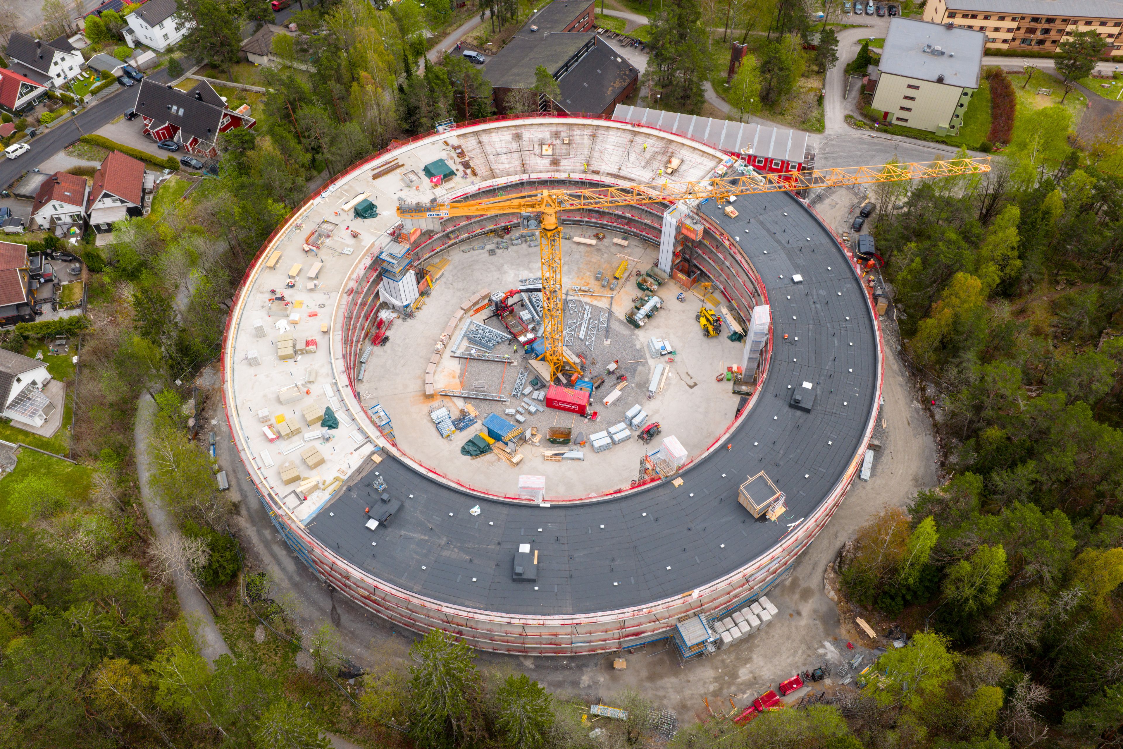 Dronefoto av Oen ovenfra, i byggeprosessen. En gul kran står i midten der gårdsrommet skal komme.