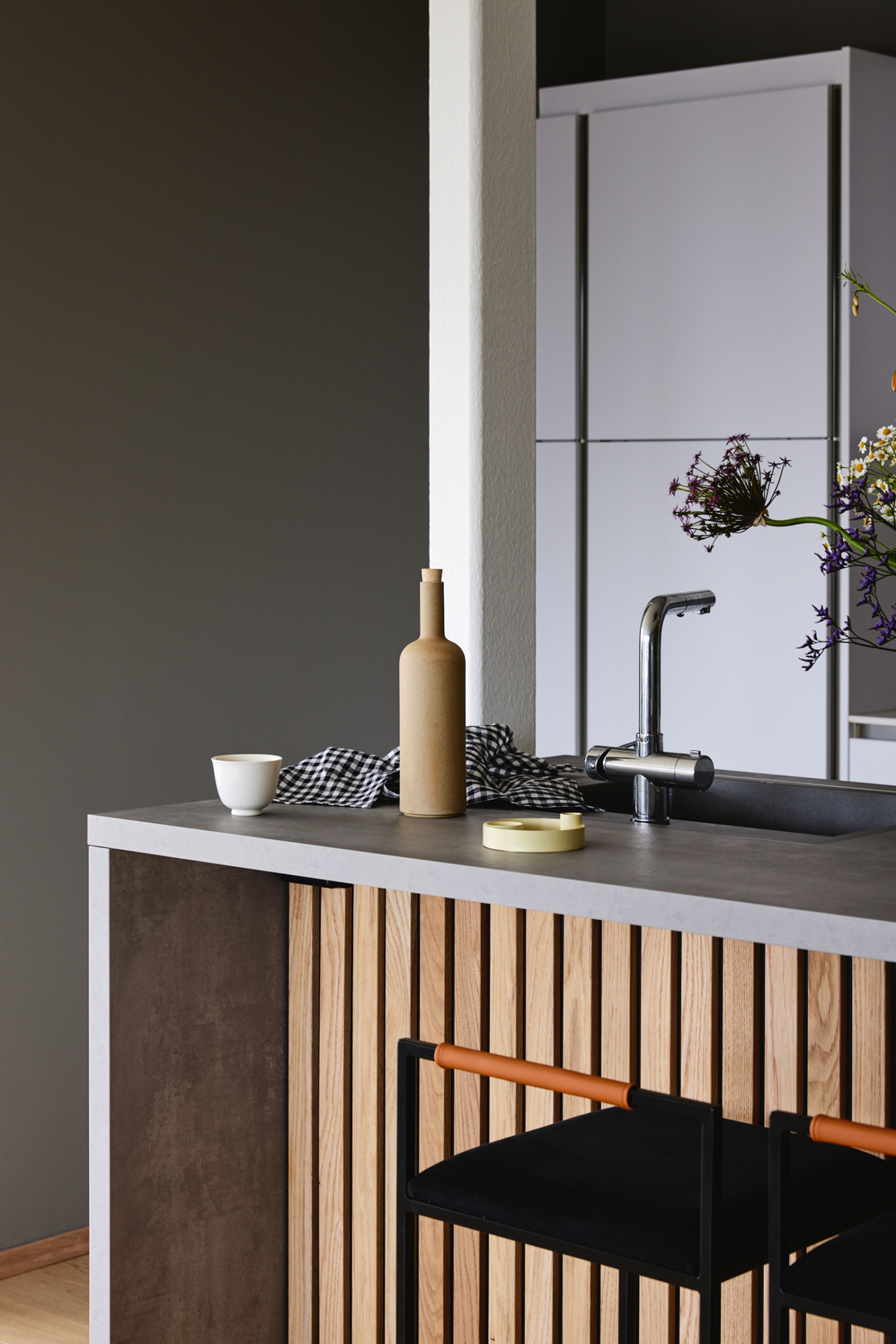 Deler av kjøkkenøy med spiler og kjøkkenskap i bakgrunnen.