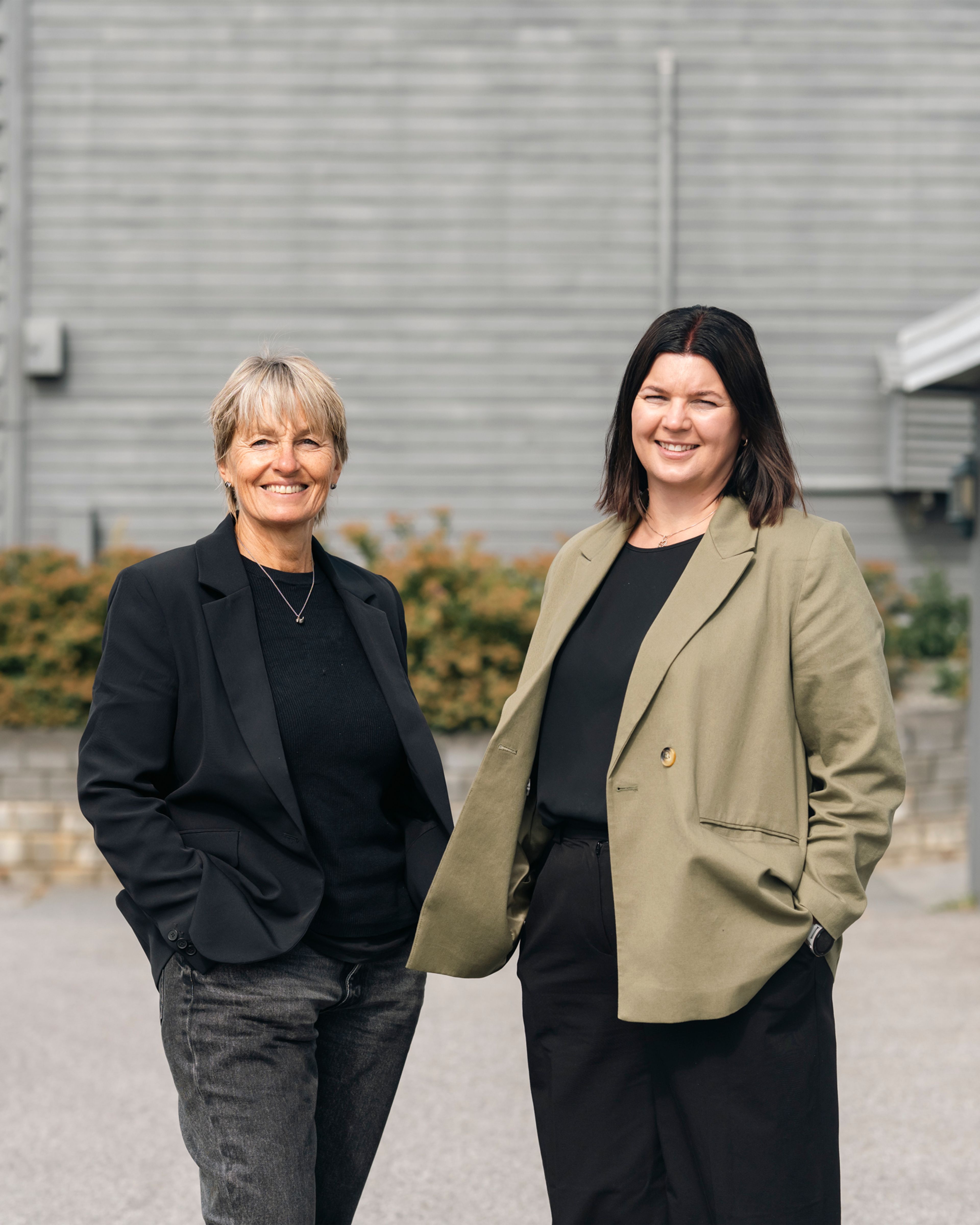 Rådgiver Kirsti Jøines og prosjekt- og byggleder Ann-Charlott Ejander står ute foran rekkehuset og smiler mot kamera.