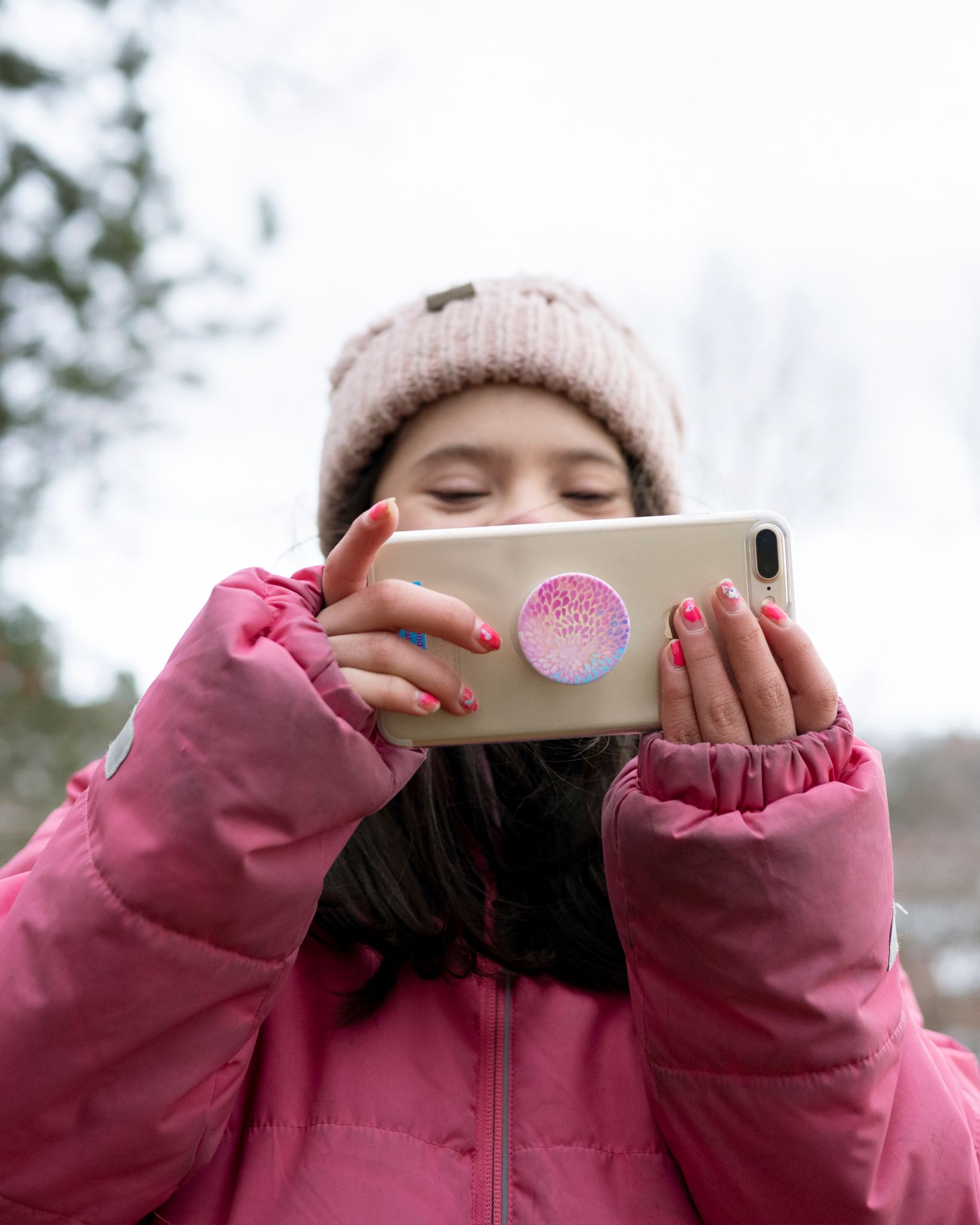 Datter på tretten tar bilde med mobilkameraet sitt