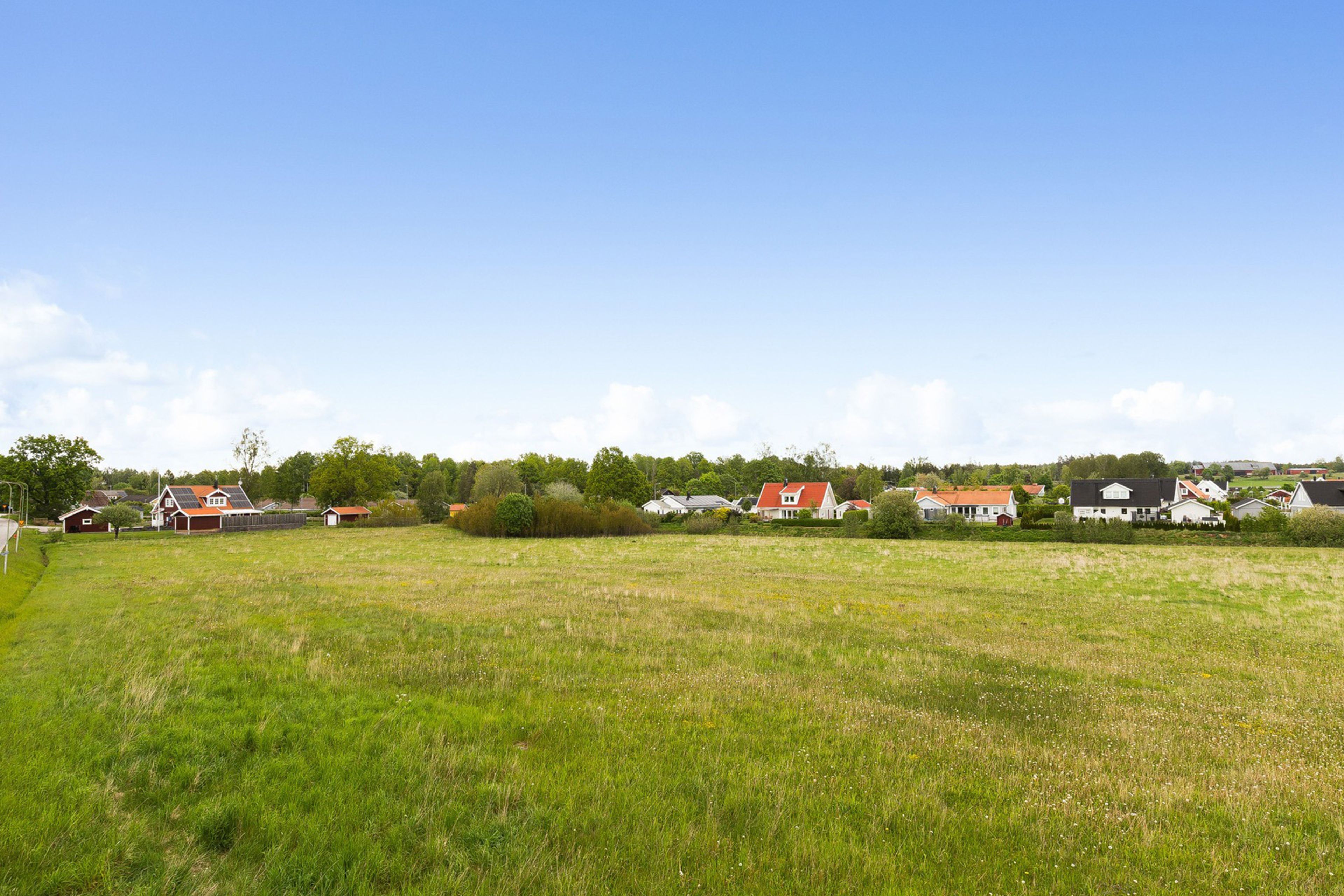 Foto på tomten där Brf Klövern ska byggas - med villakvarter i bakgrunden