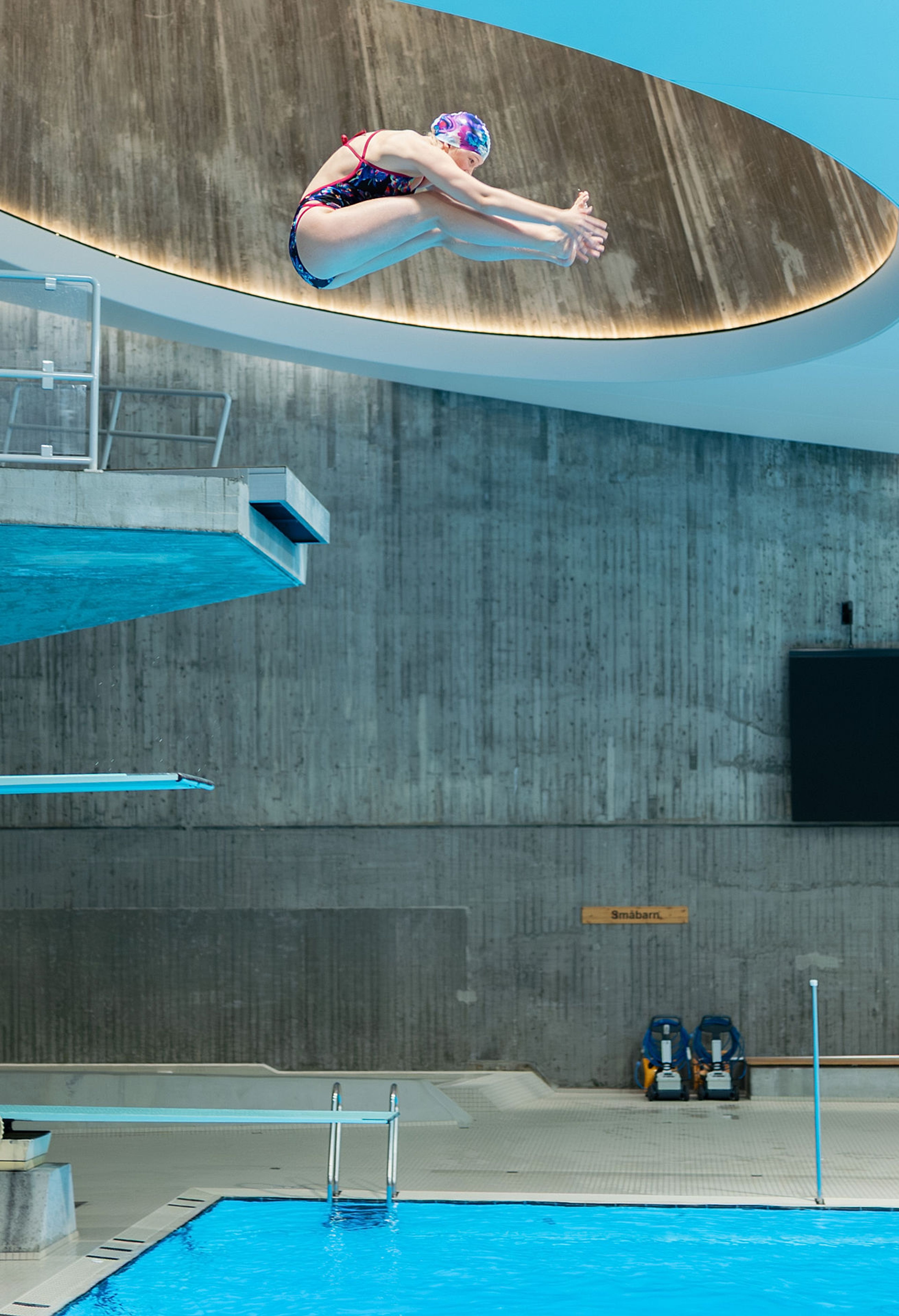 Jenta hopper, og holder hendene mot beina.