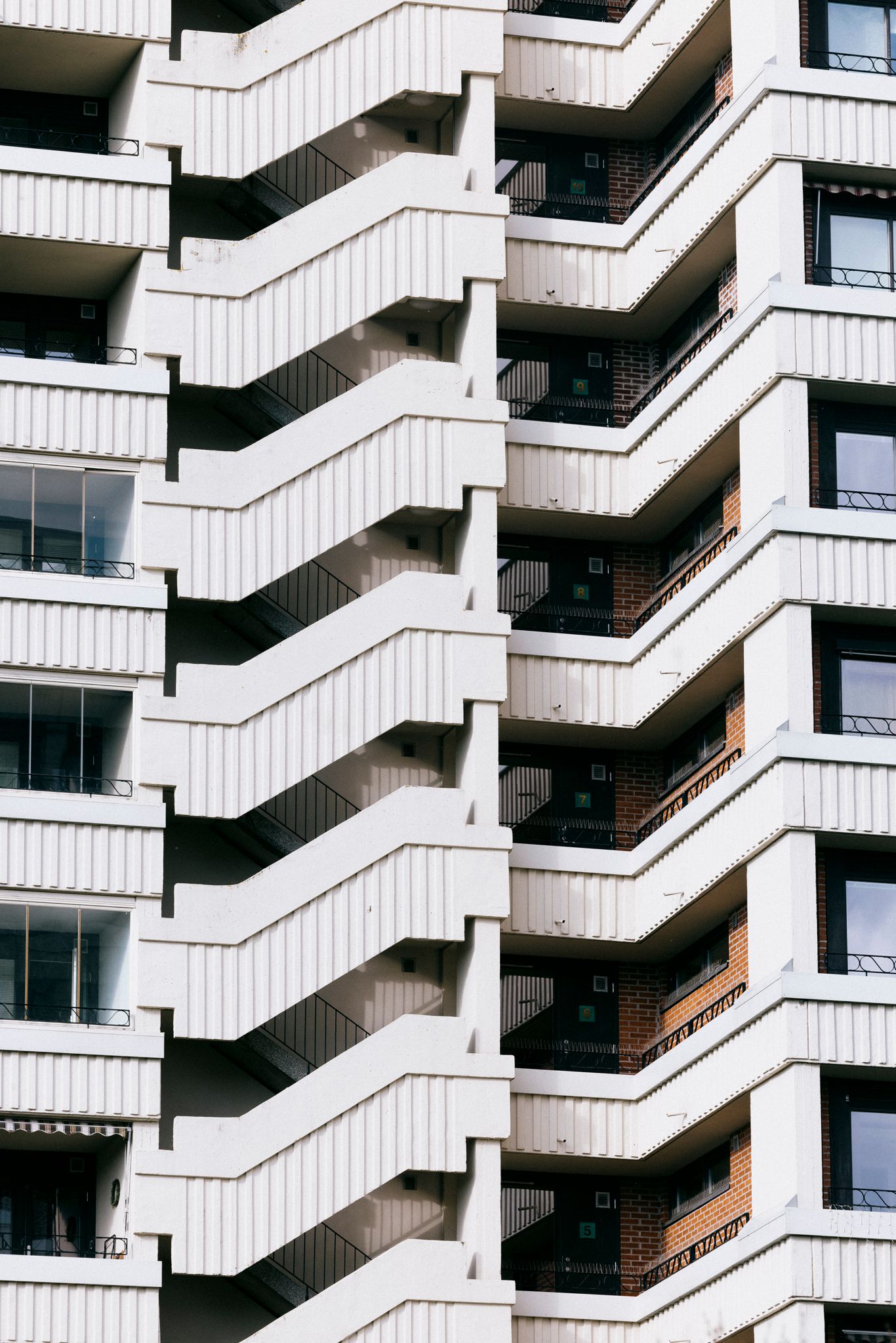En høyblokk på Tveita med ulike linjer på fasaden, med balkong, trapper og vinduer.