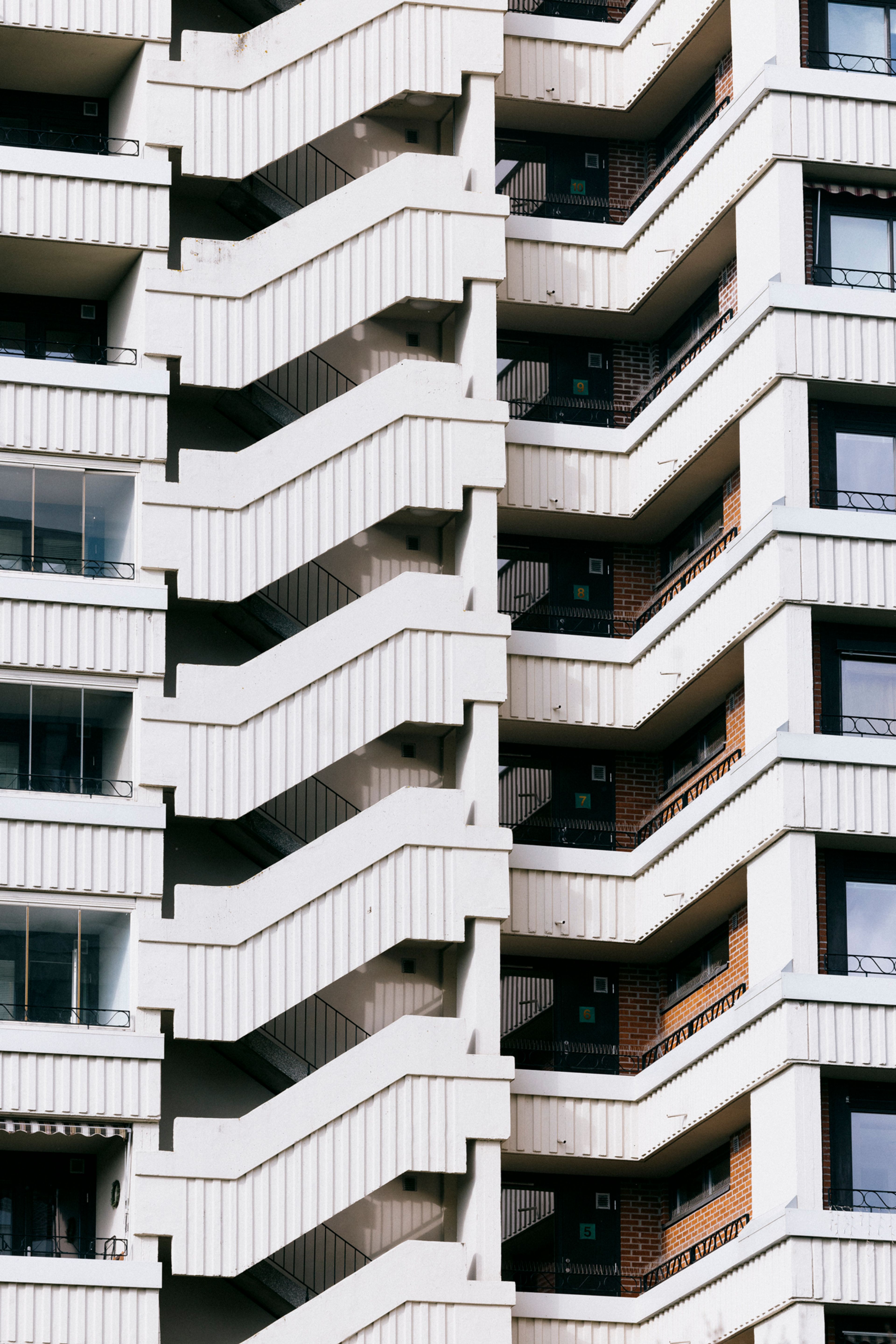 En høyblokk på Tveita med ulike linjer på fasaden, med balkong, trapper og vinduer.