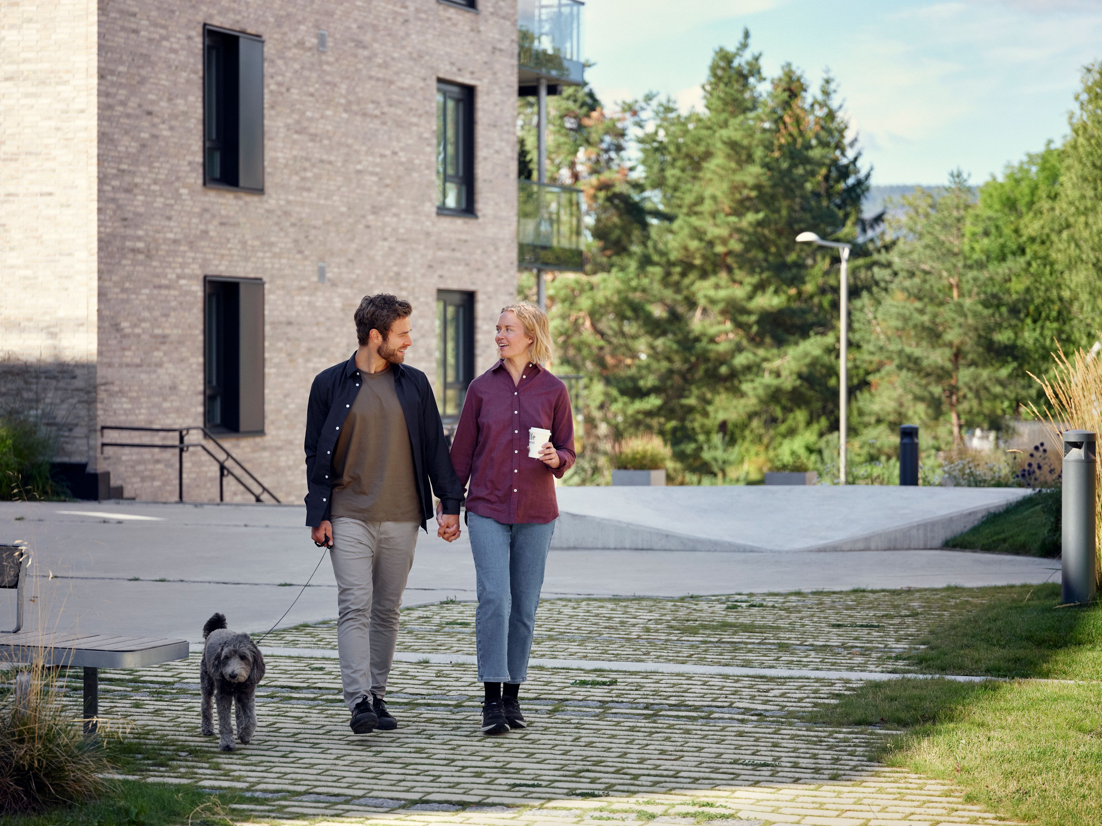 Kvinne og mann går tur med hunden sin