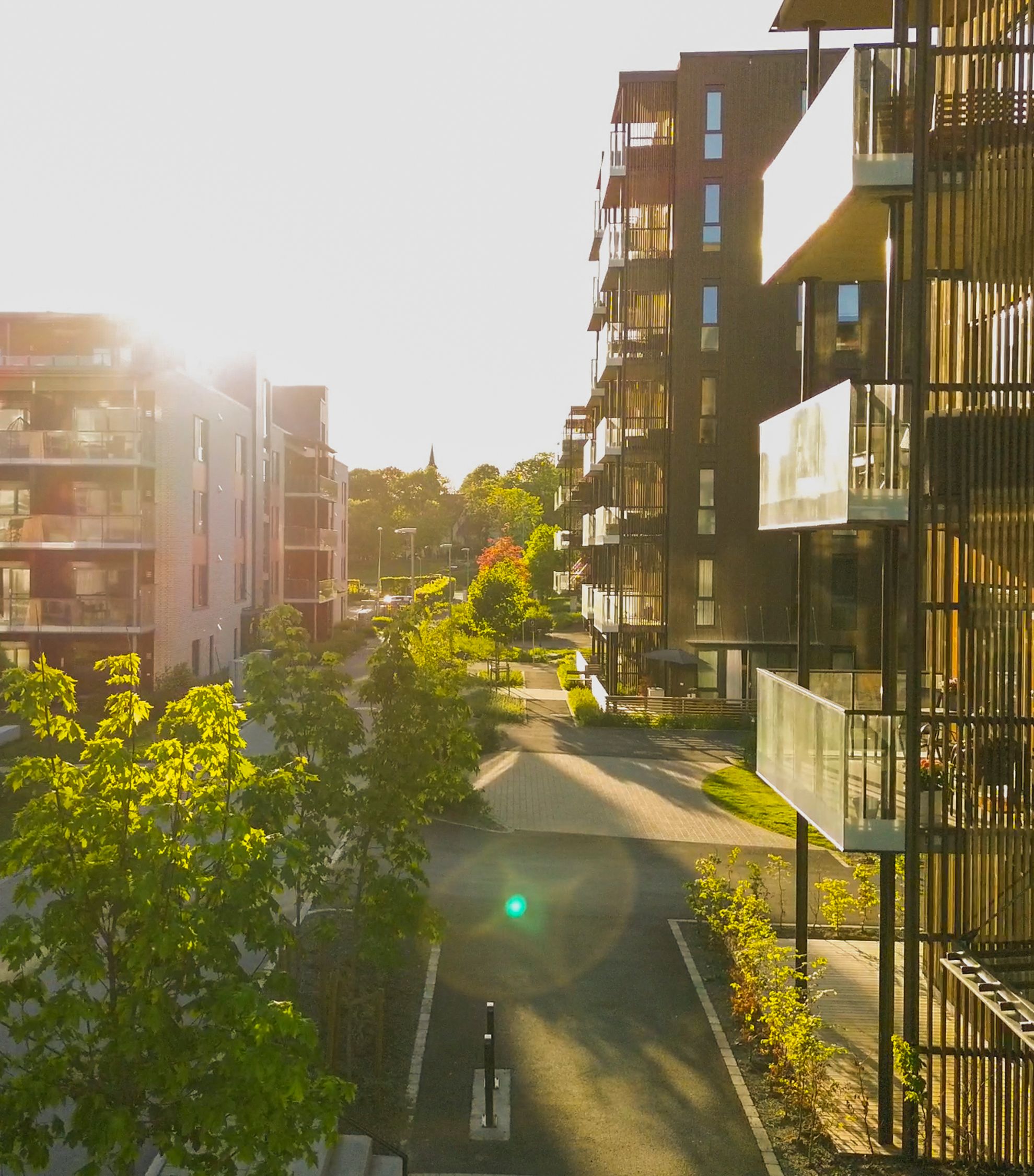 Foto av uteområdet til et borettslag, tatt fra en balkong i andre etasje.