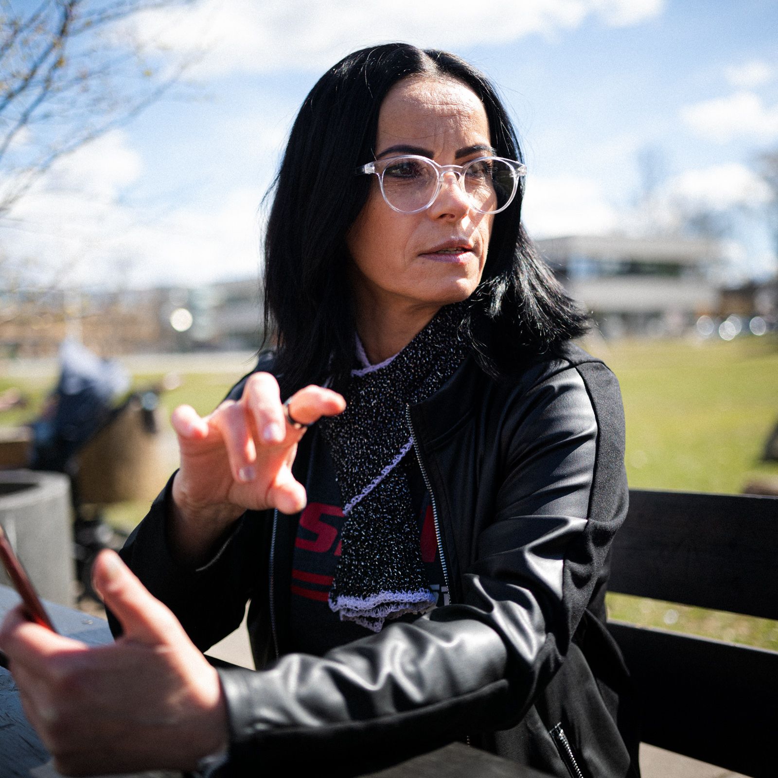 Foto av Mihaela som sitter på en benk i parken.