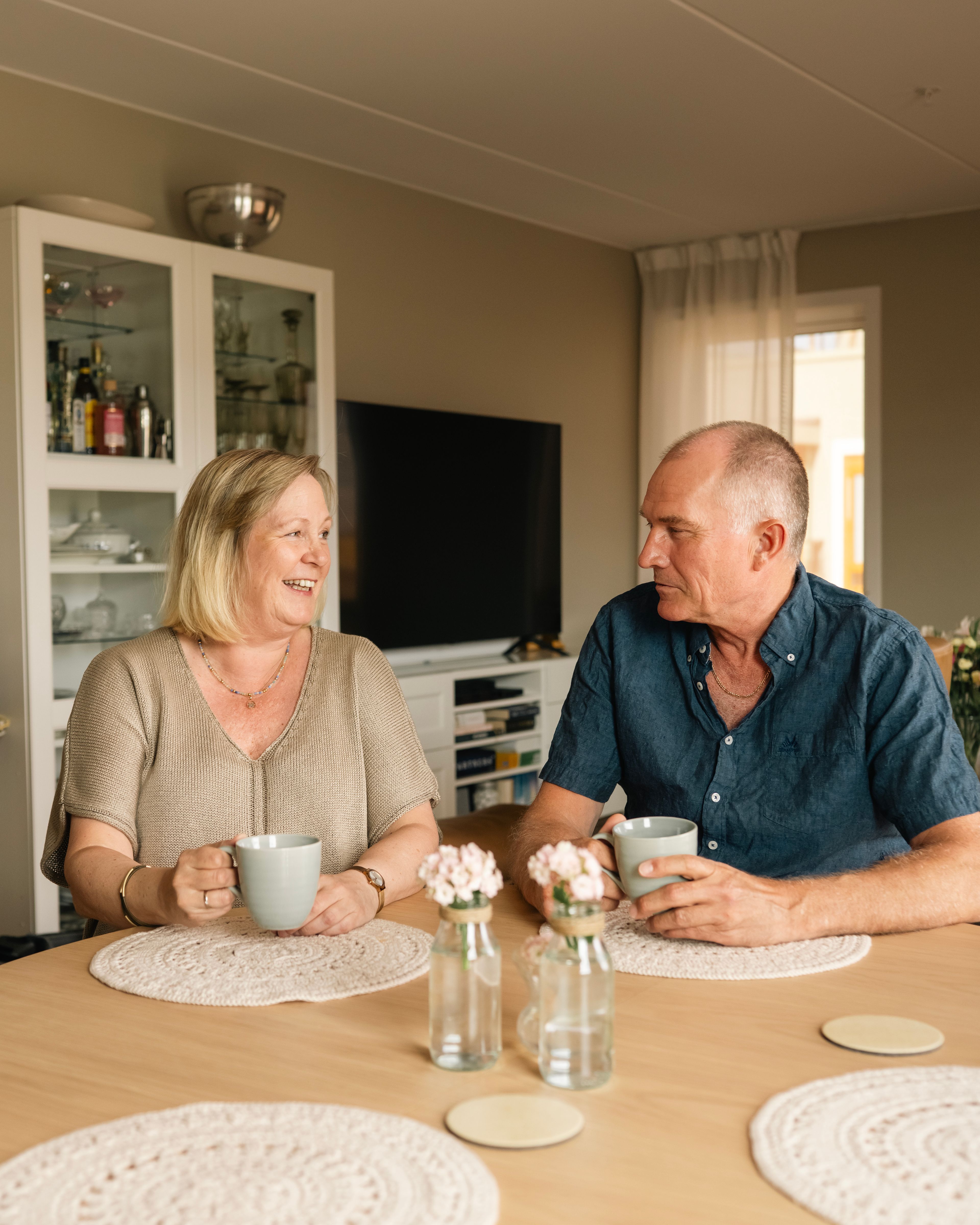 Foto av Helene og Morten med hver sin kaffekopp i hånda, sittende ved spisebordet i sin nye leilighet på Kvarteret i Lillestrøm