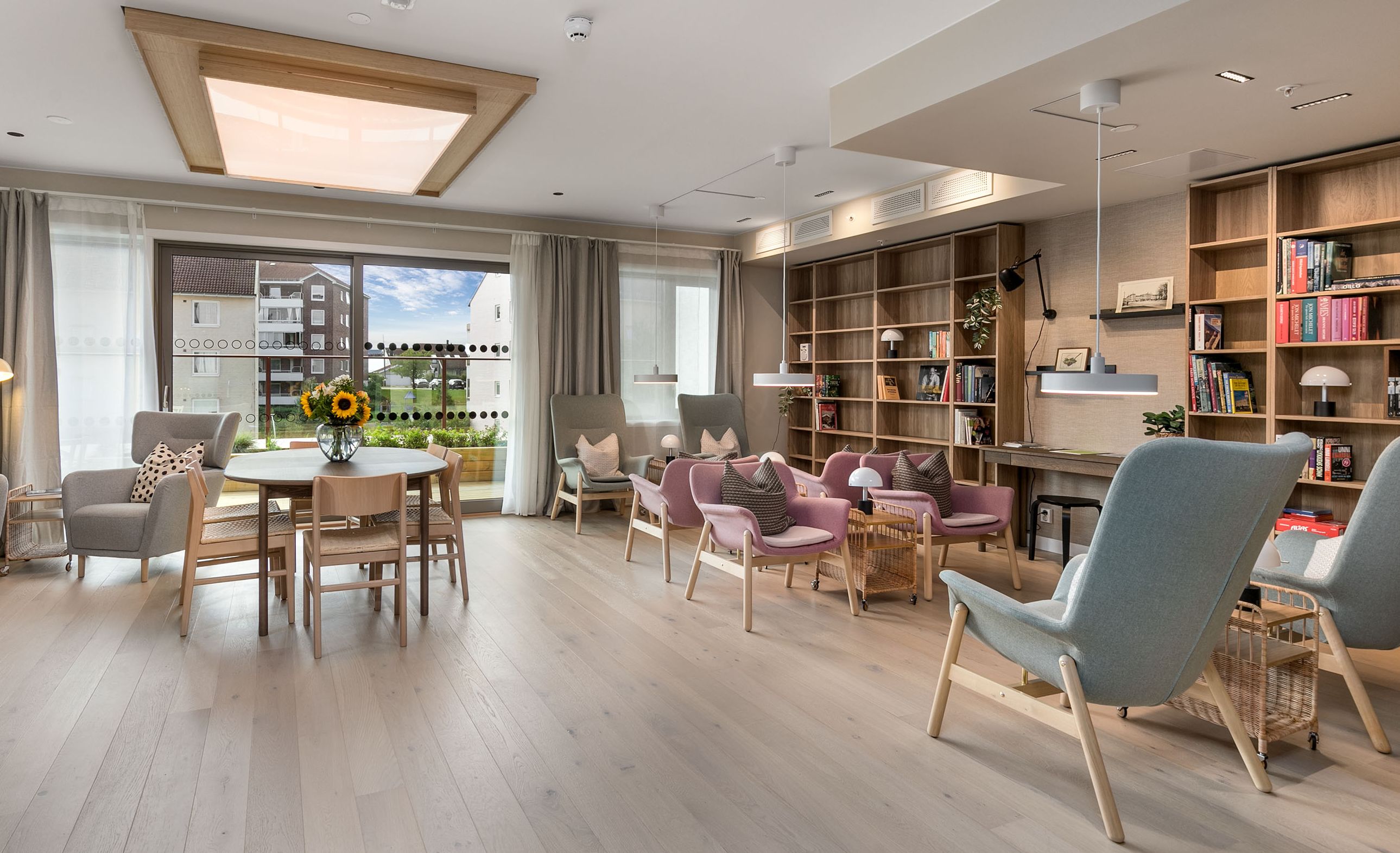 Fellesstue i Bølgelengden, innredet med hyller, stoler, sofa og bord.