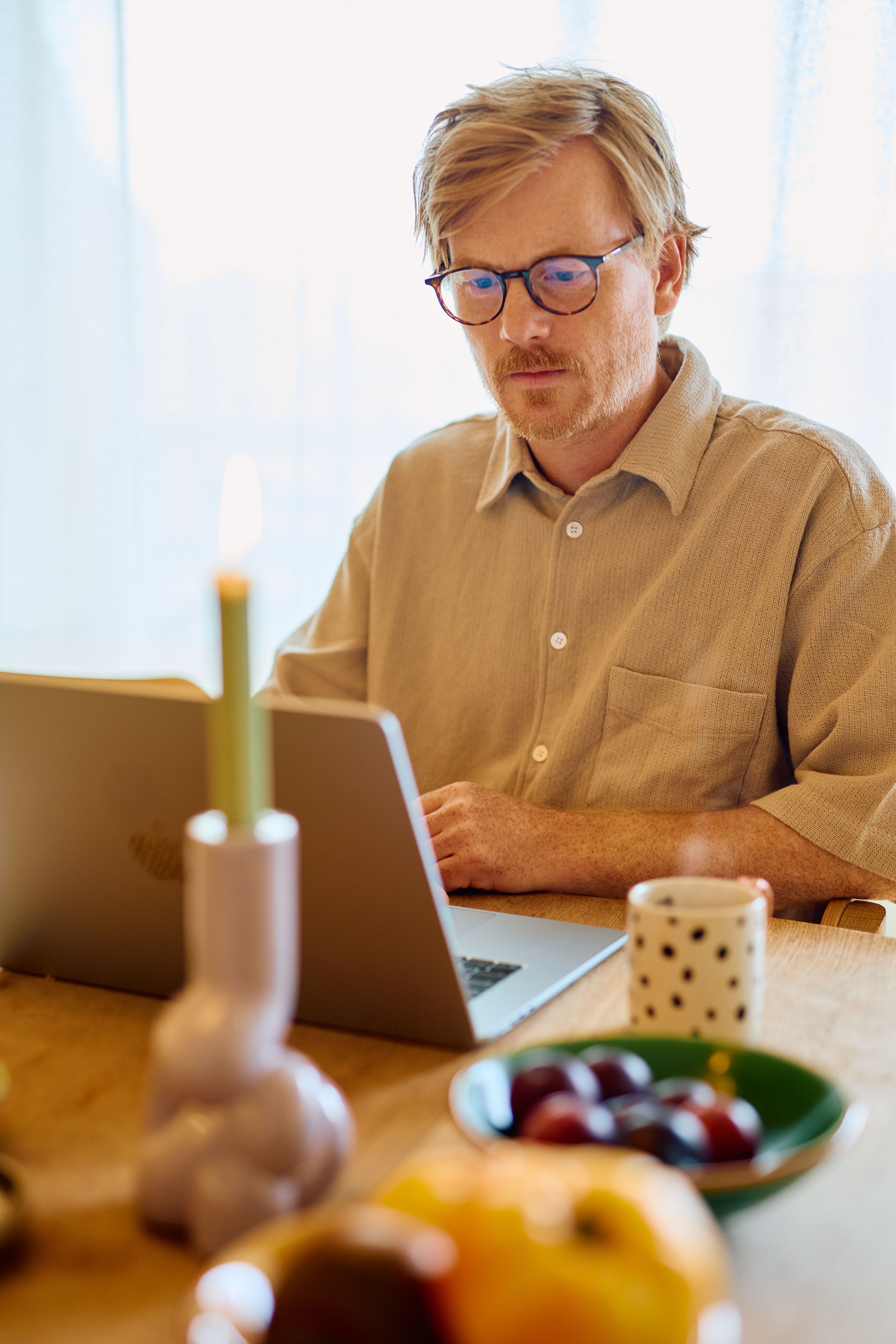 En mann med hodetelefoner og mikrofon sitter ved PCen.