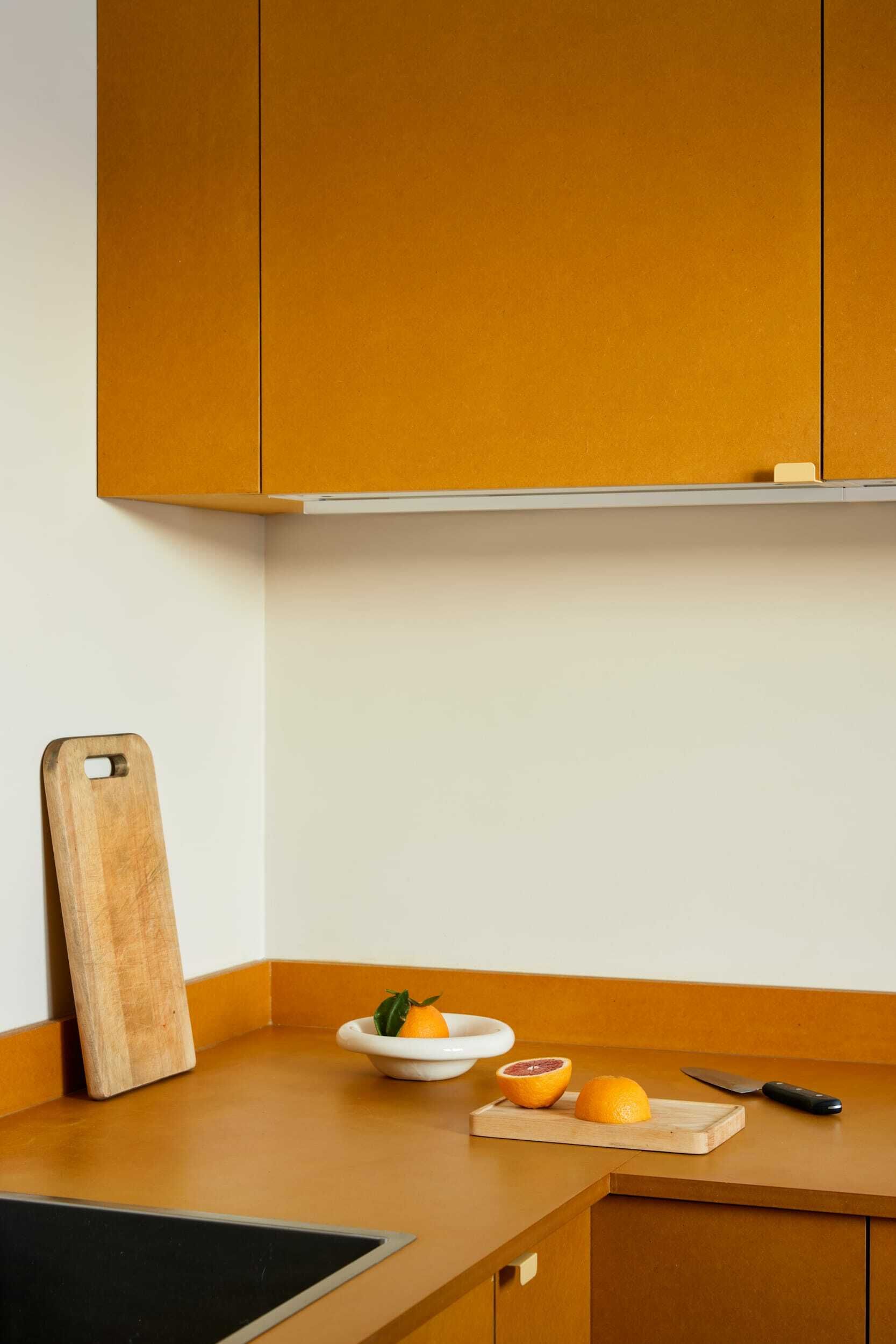 Kjøkkenhjørne med gule kjøkkenfronter og gul benkeplate.