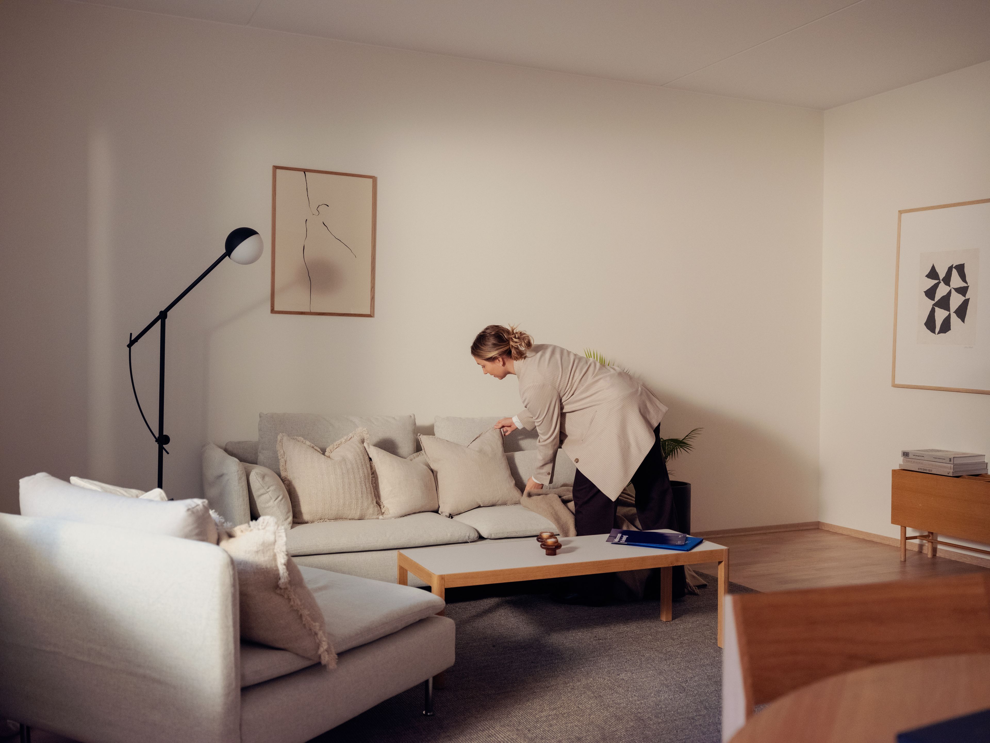 En interiørstylist styler en stue før foto og visning.