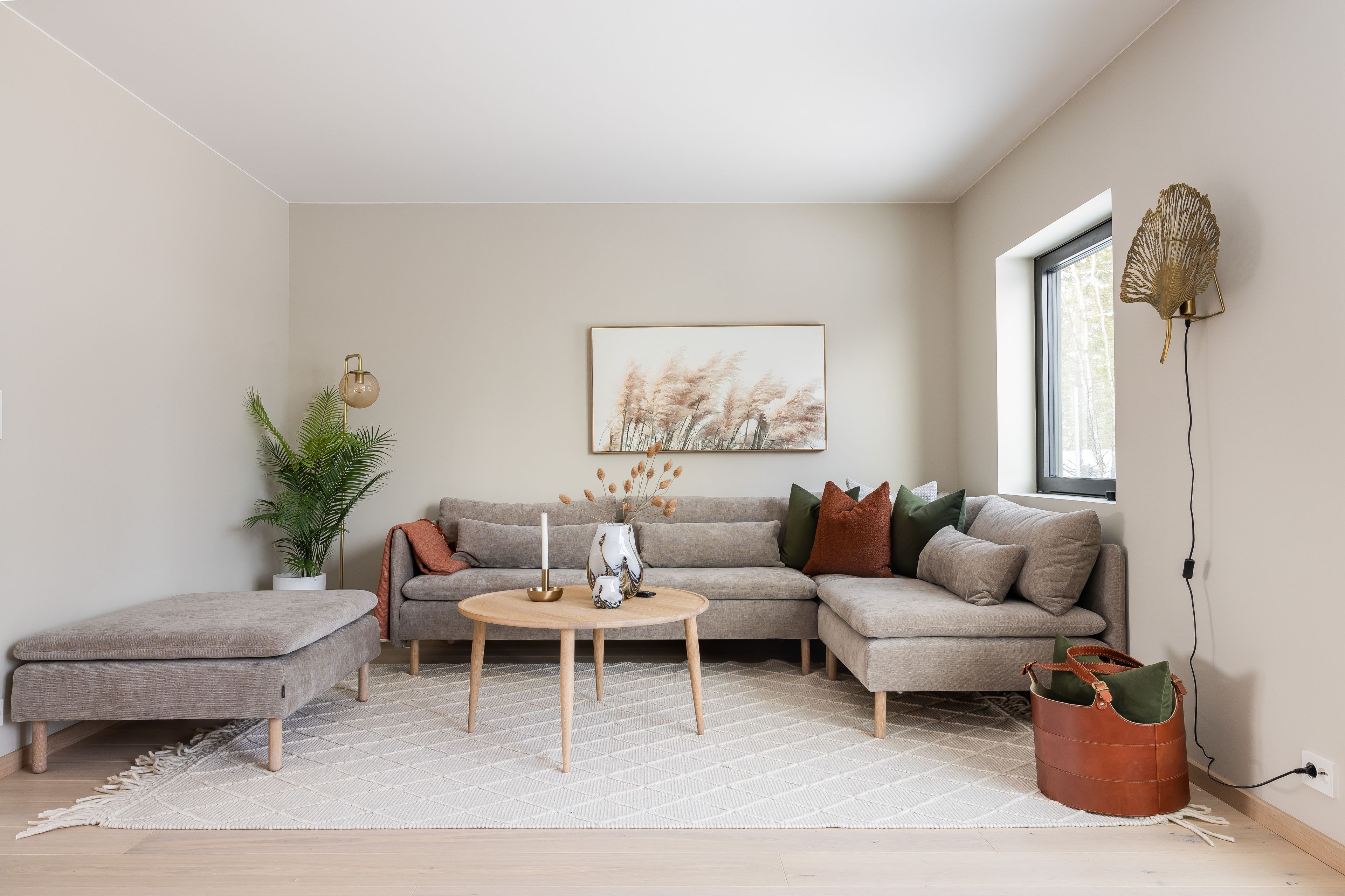 Foto av stue med stor sofa og rundt bord.