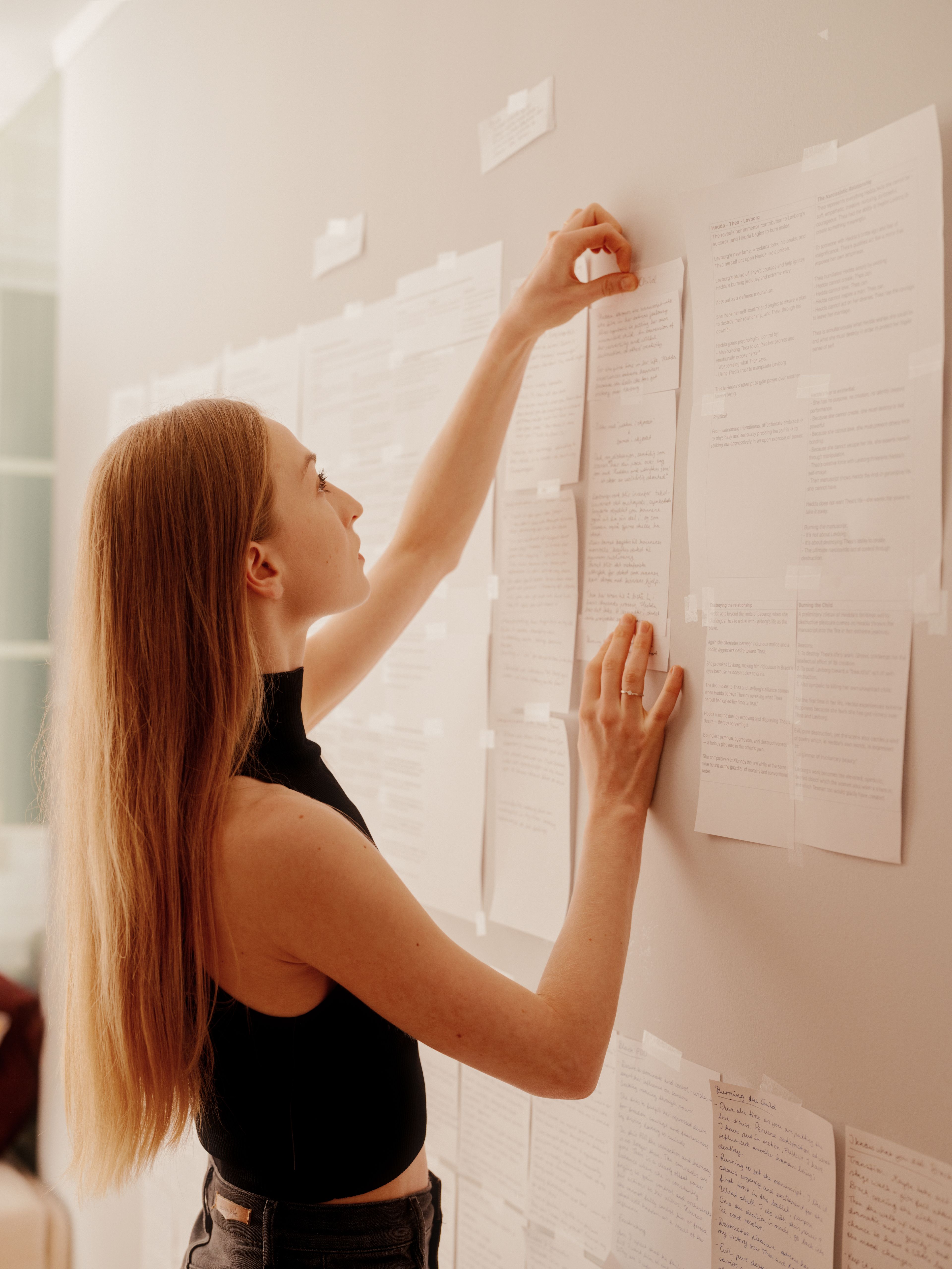 Grete Borud Nybakken henger opp manuset på veggen hjemme.