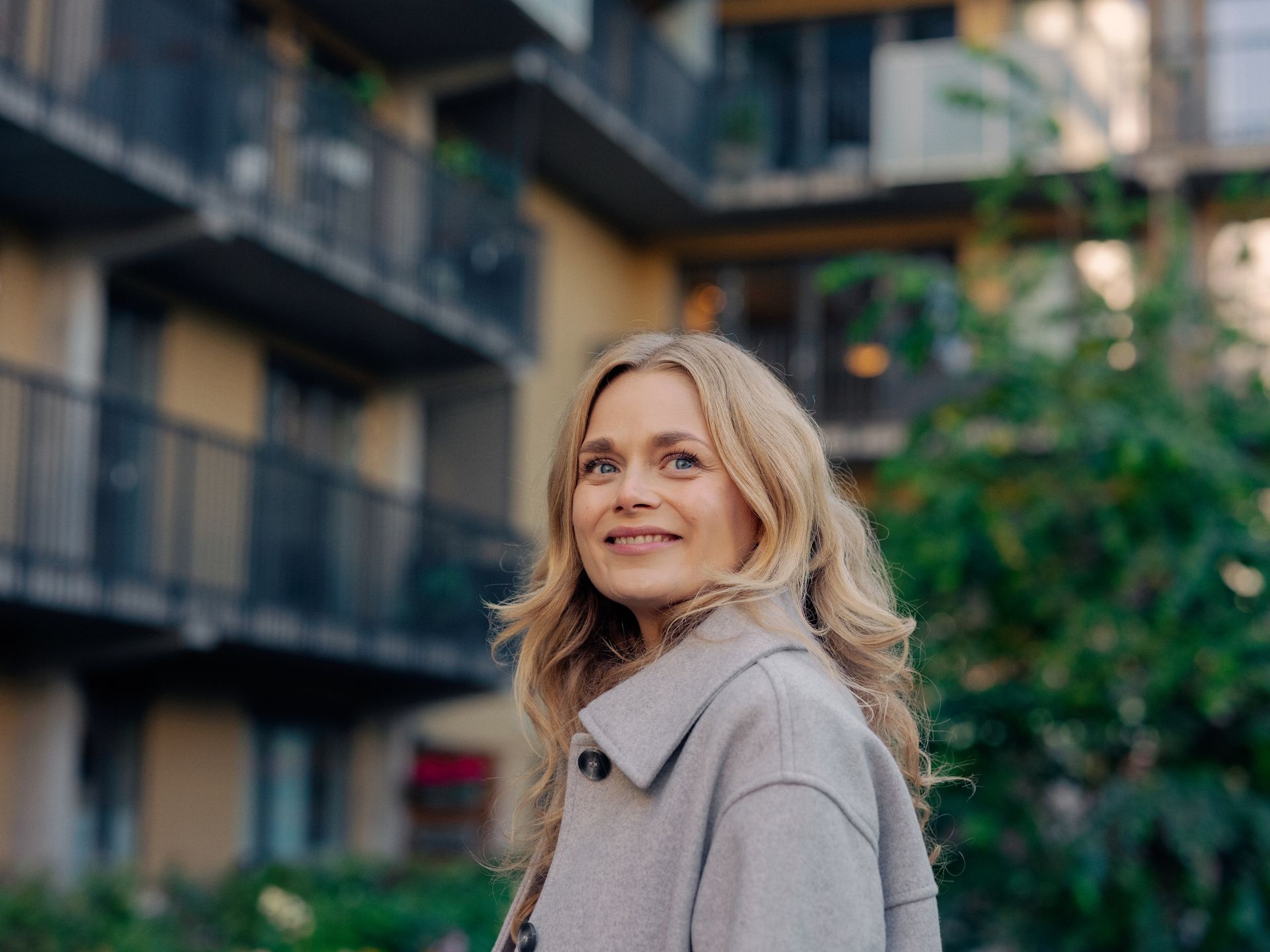 Ung kvinne foran boligblokk