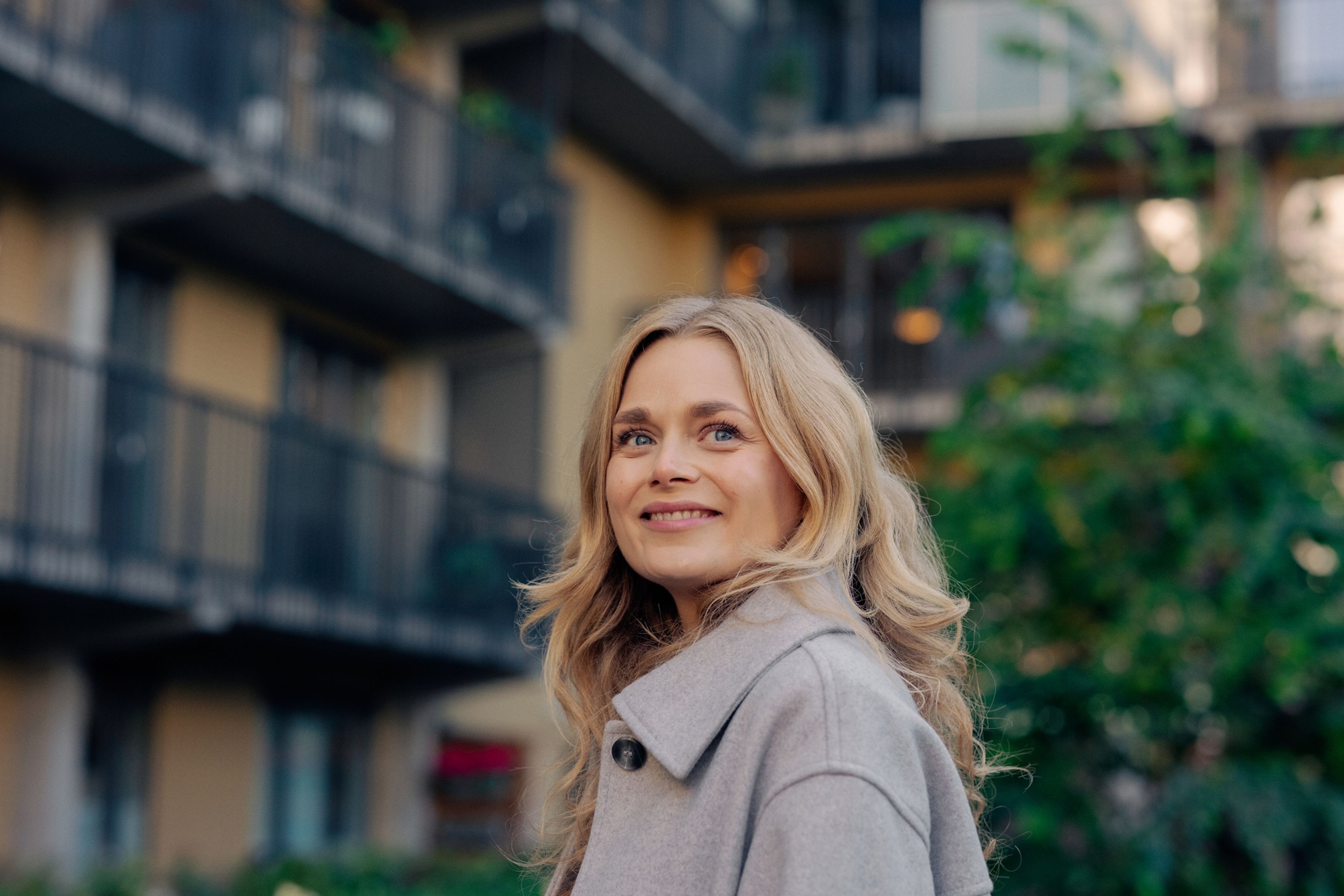 Ung kvinne foran boligblokk