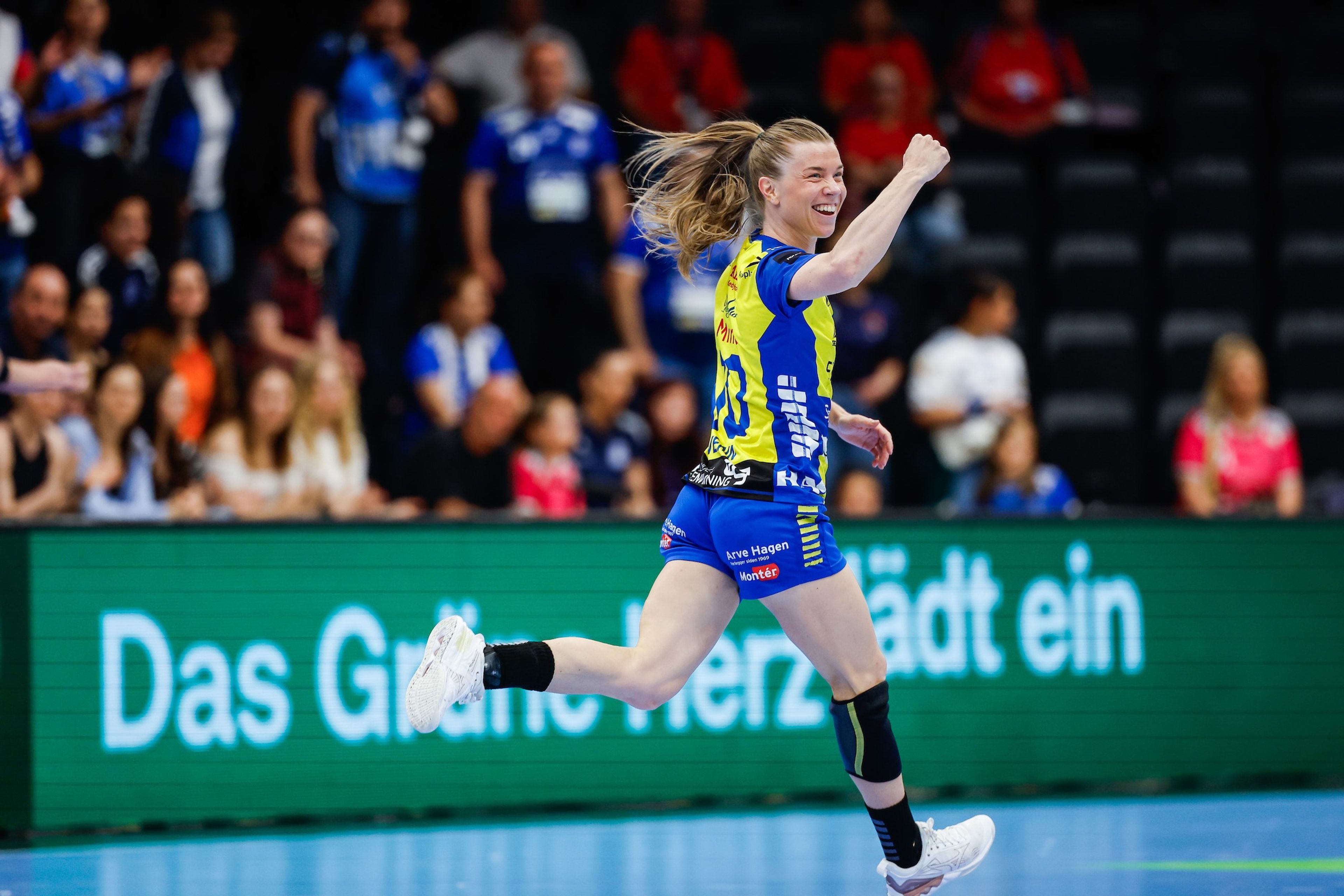 Foto av en Storhamar Håndball spiller som smiler på banen.