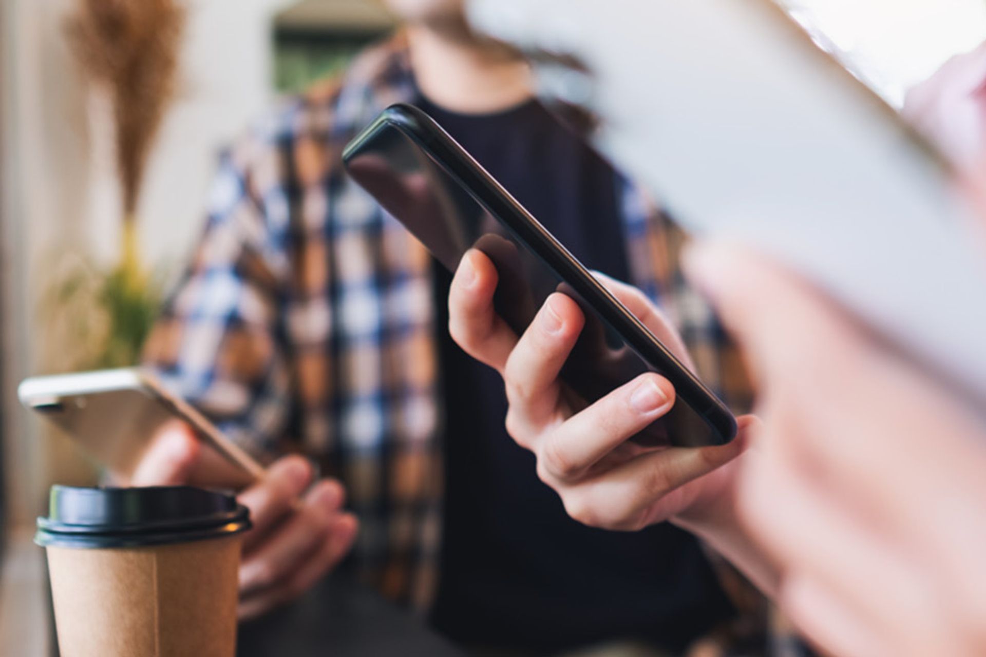 To personer holder hver sin smarttelefon