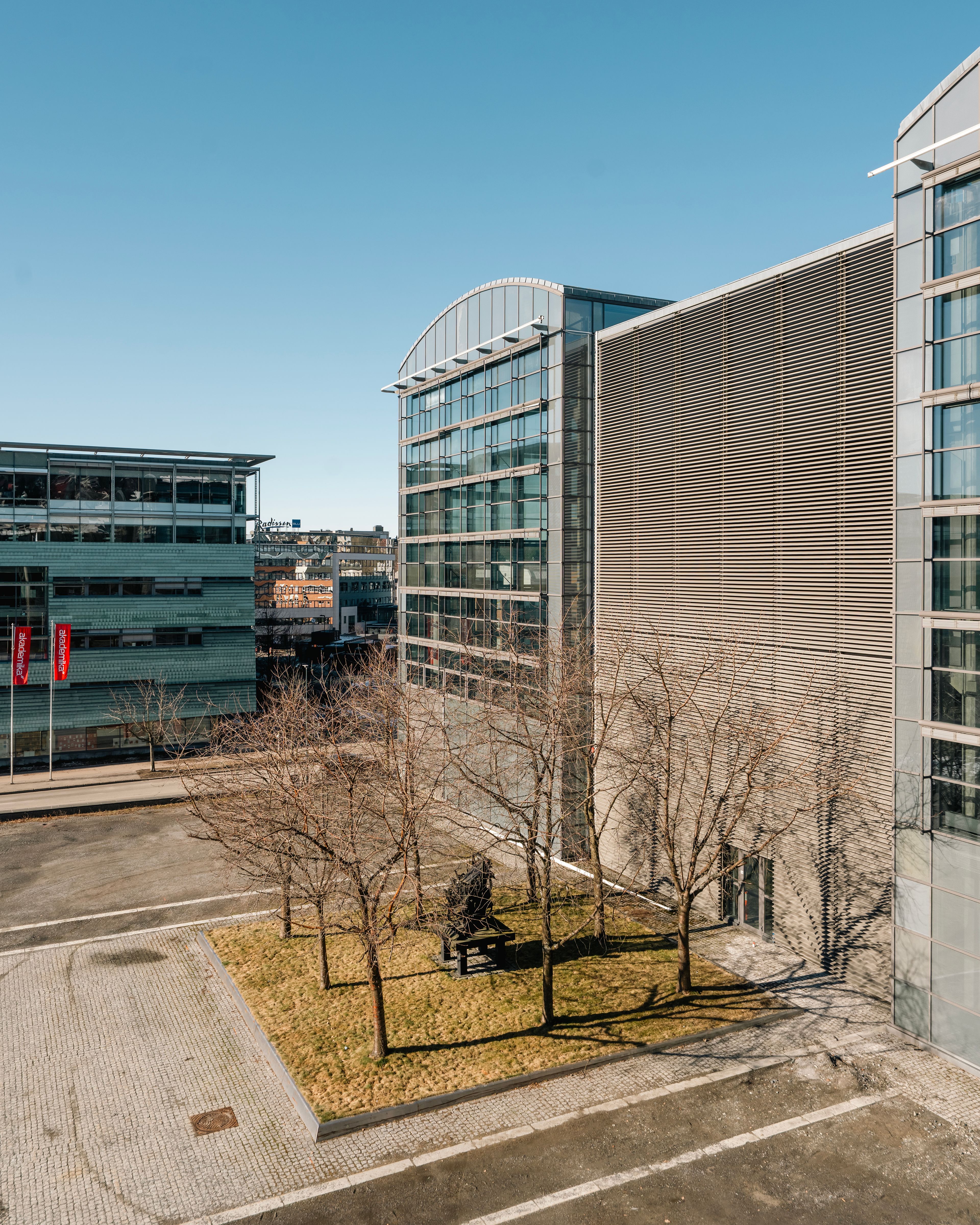 Foto av fasaden på de gamle trykkerihallene i Nydalen, og plassen foran dem.