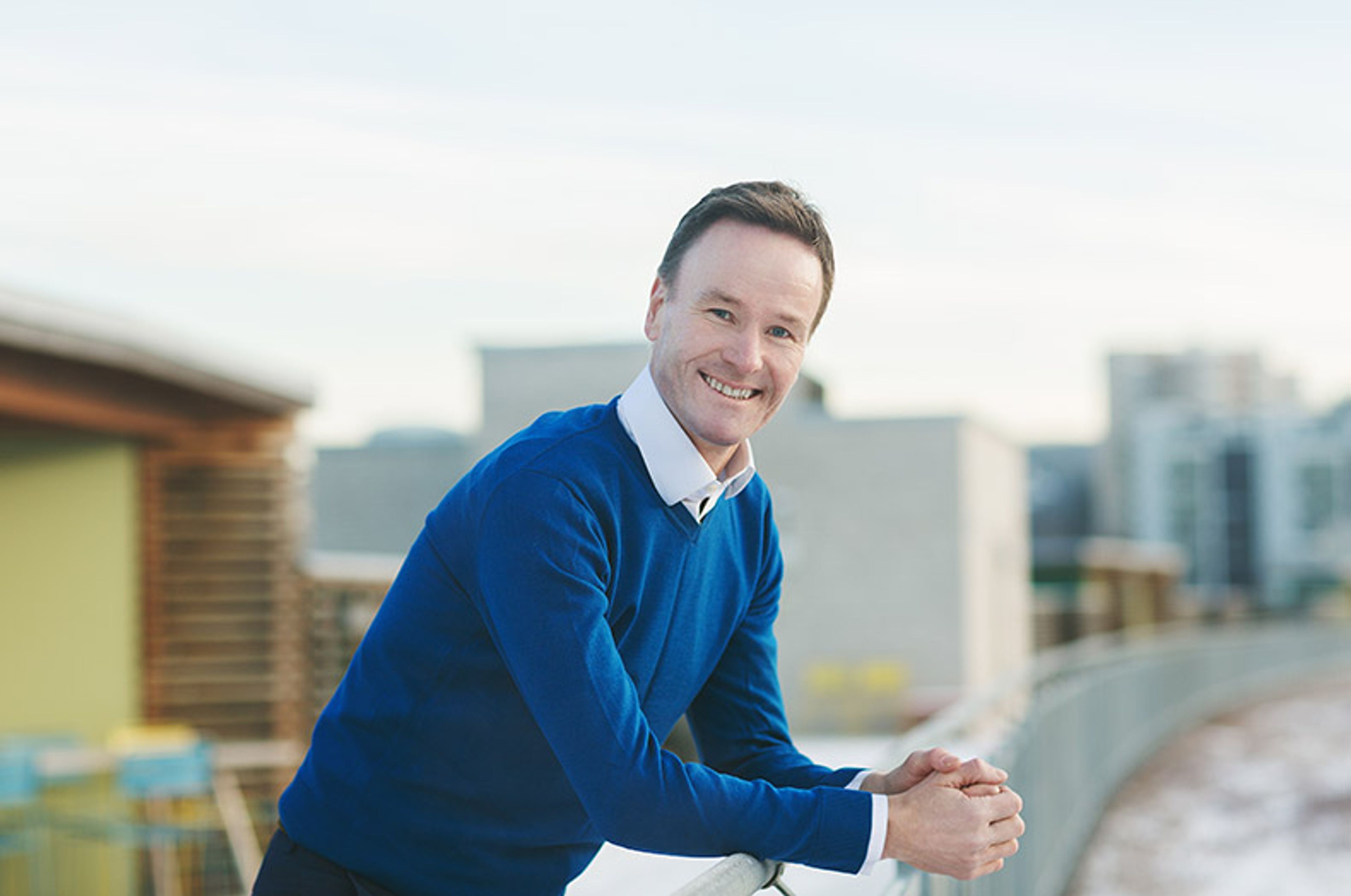 Nils Tore Gjone står på en balkong og smiler til kamera.