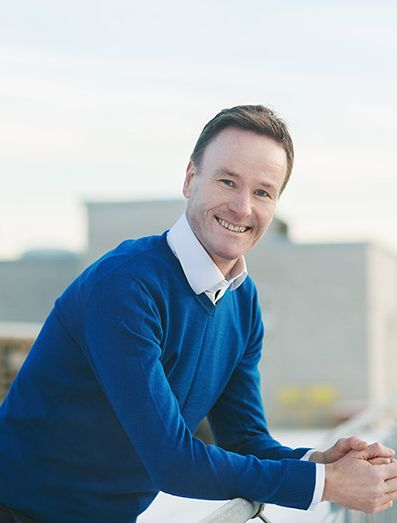 Nils Tore Gjone står på en balkong og smiler til kamera.