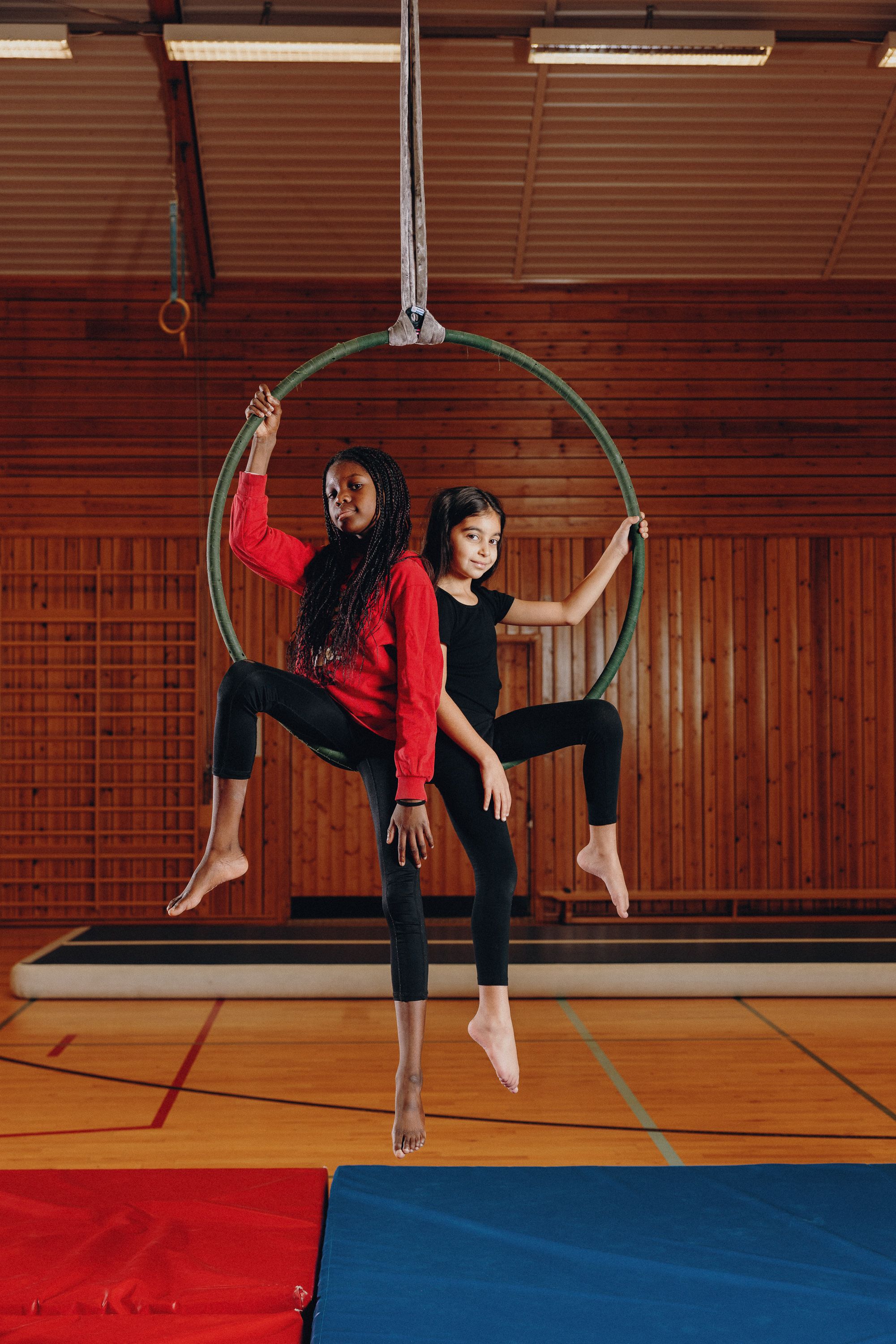 To unge akrobater sitter inne i en akrobatring