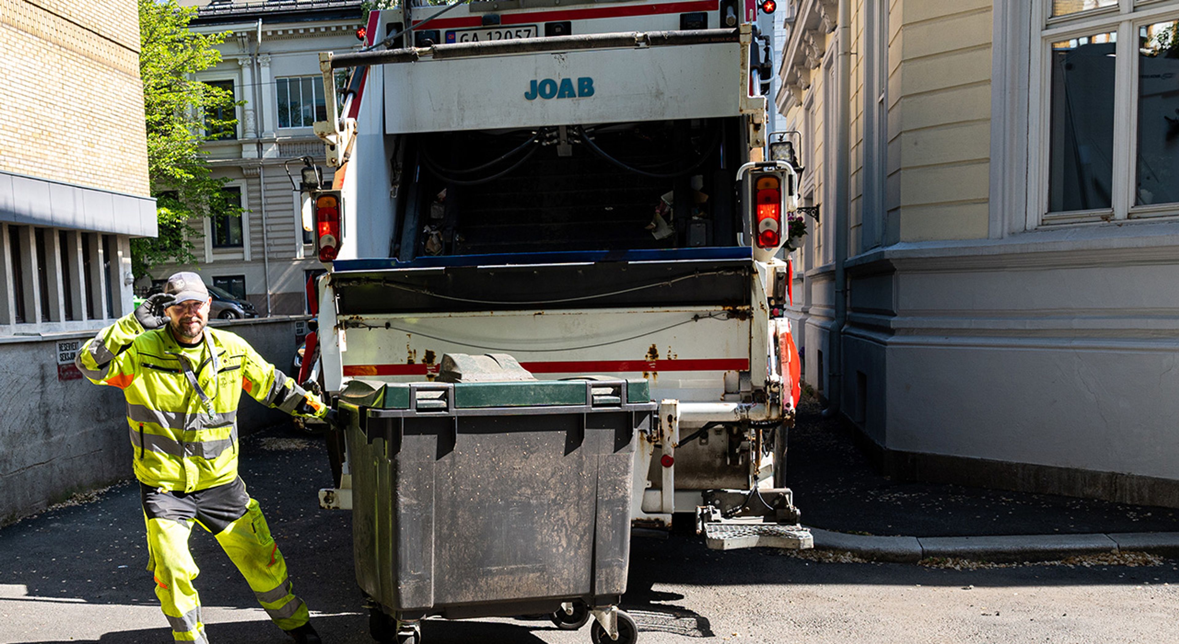 En renovasjonsmedarbeider henter avfall.